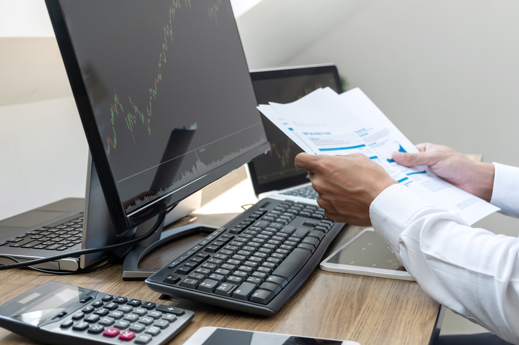 cropped hands of man analyzing graphs on computer over table