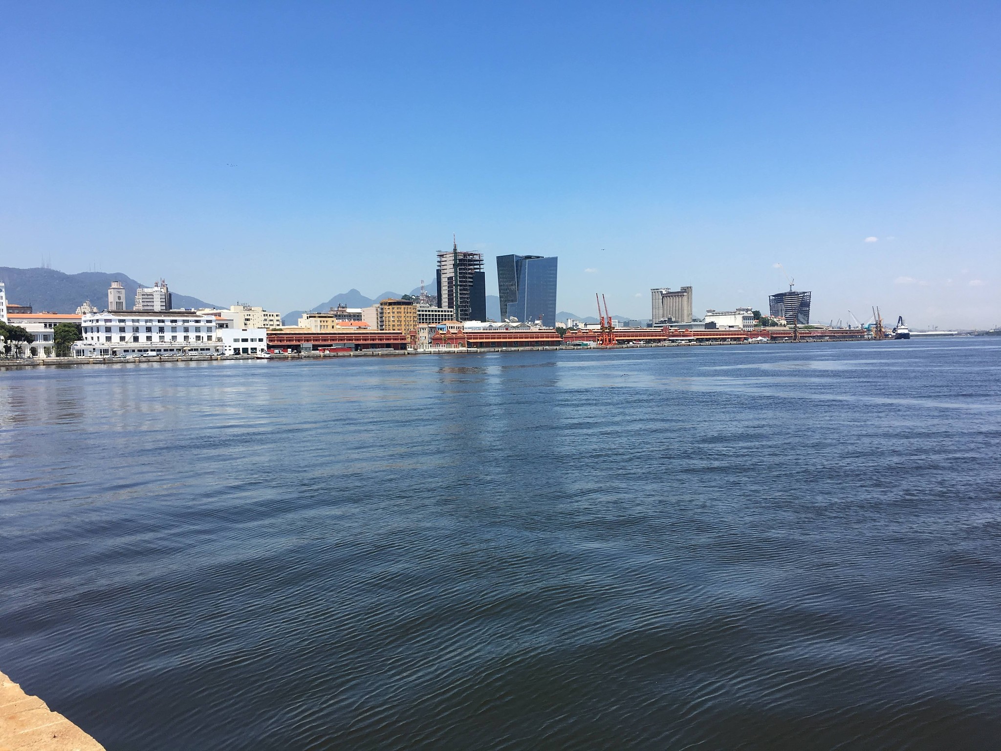sea by buildings against clear blue sky
