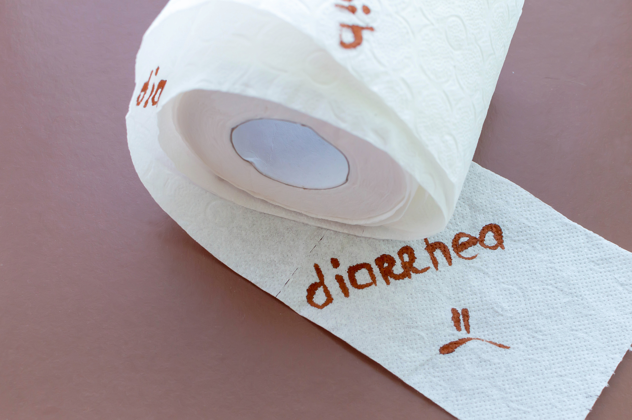 a roll of white toilet paper labeled "diarrhea" on a brown backg