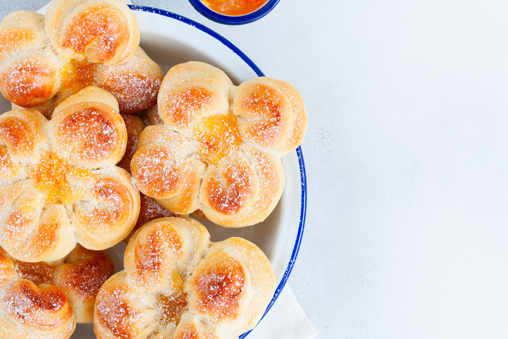 beautiful yeast buns in the shape of flowers in an enameled bowl