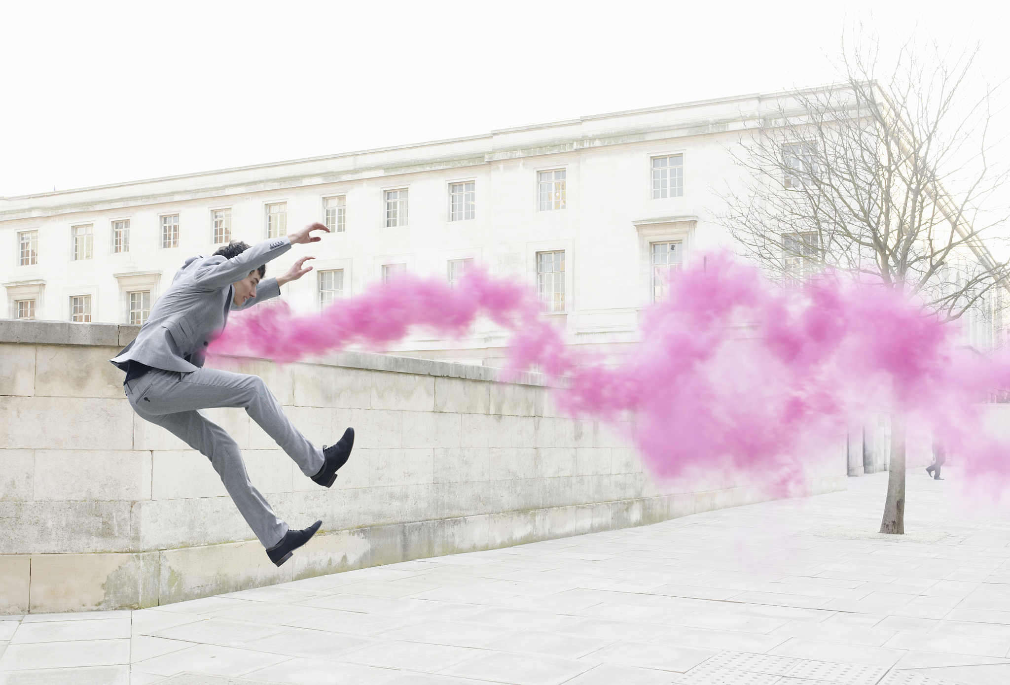business man getting thrown in air by pink smoke