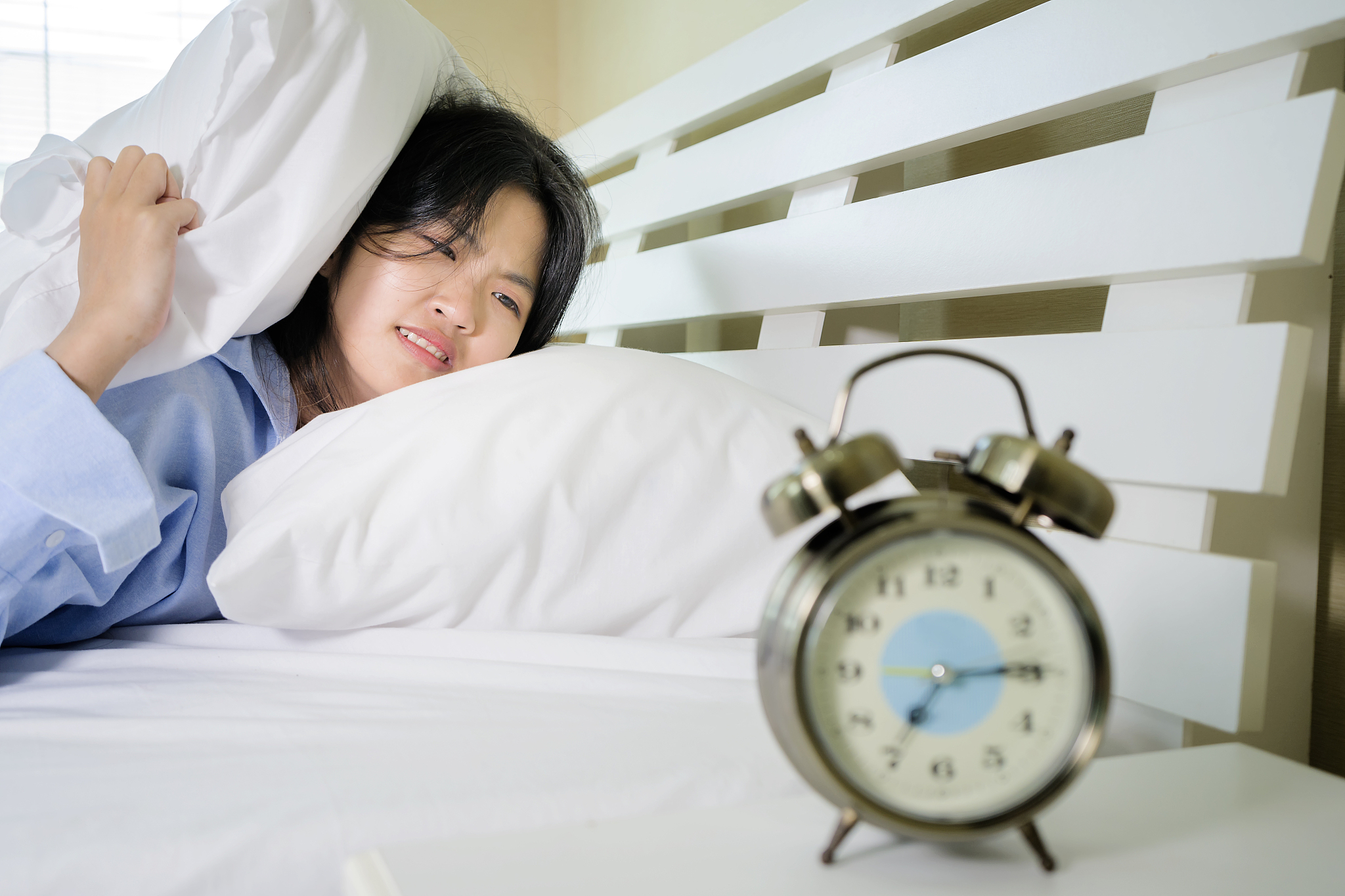 an asian woman who does not want to wake up.
