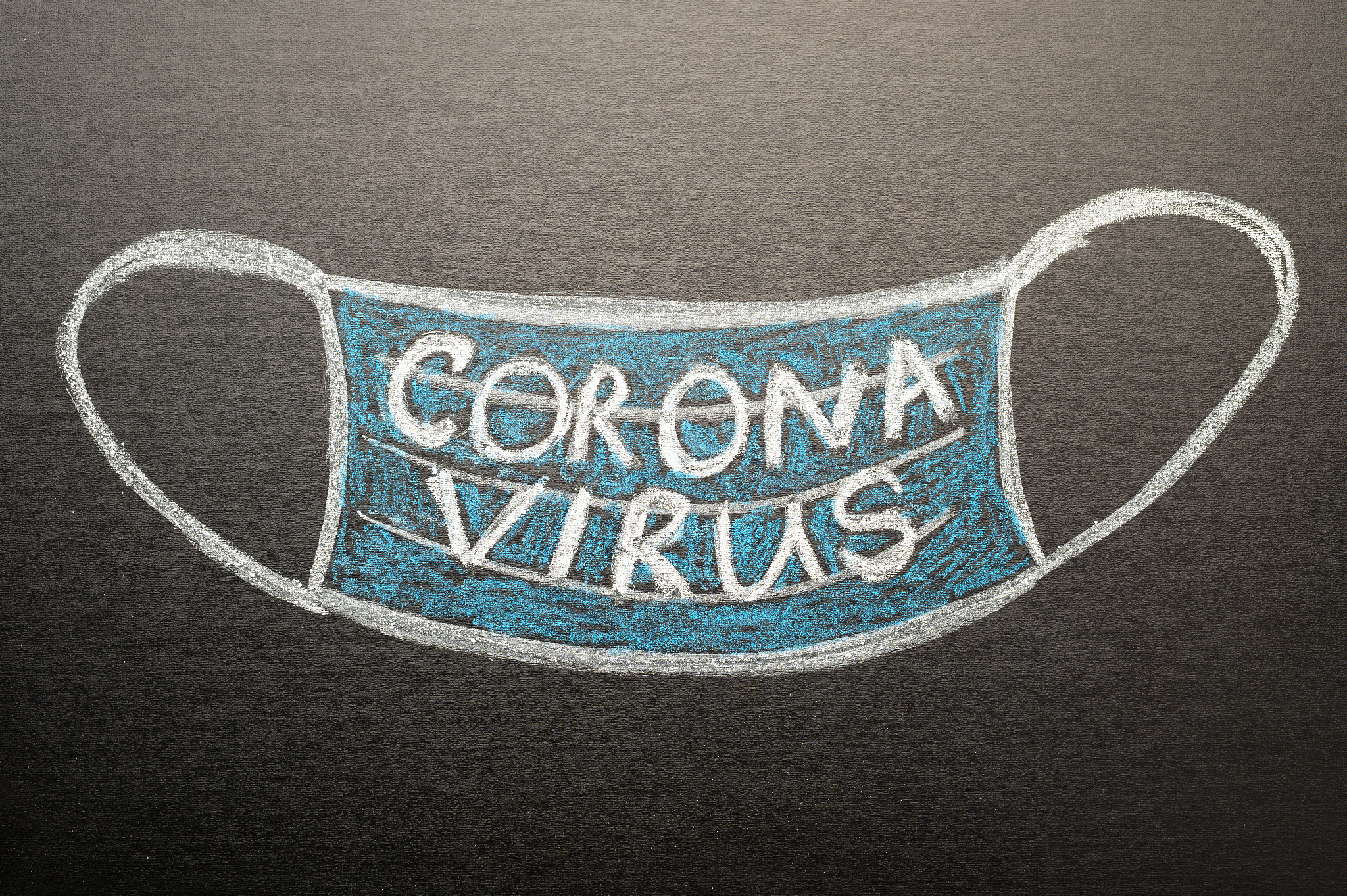 a drawn mask on a blackboard with the inscription coronavirus. n