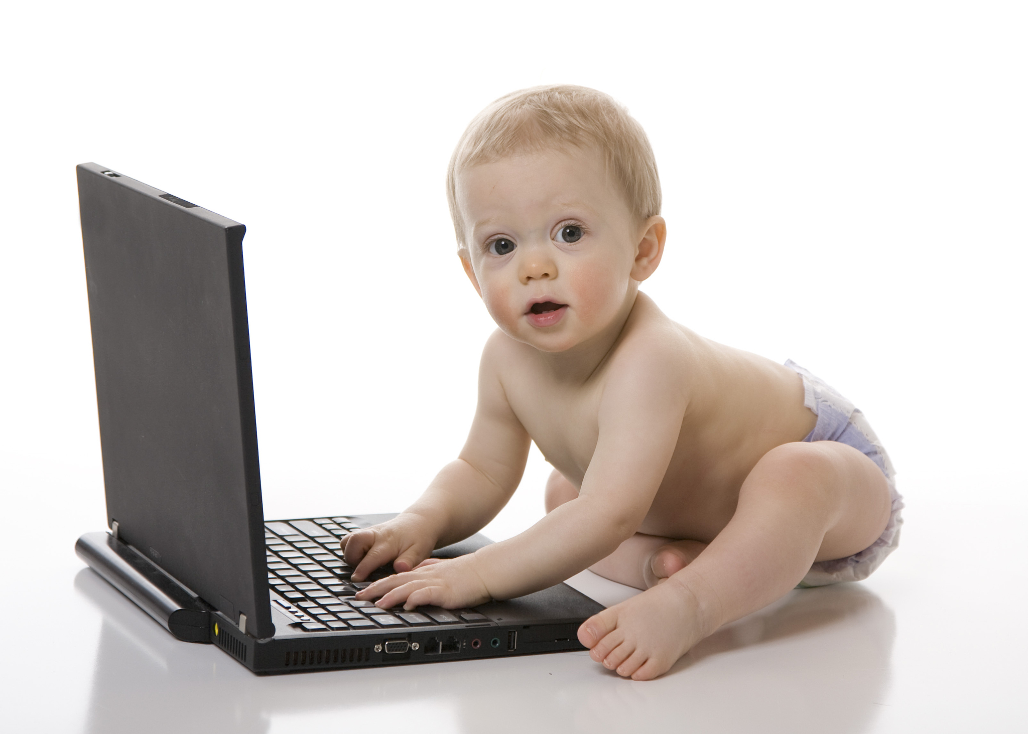 baby boy looking up from laptop computer