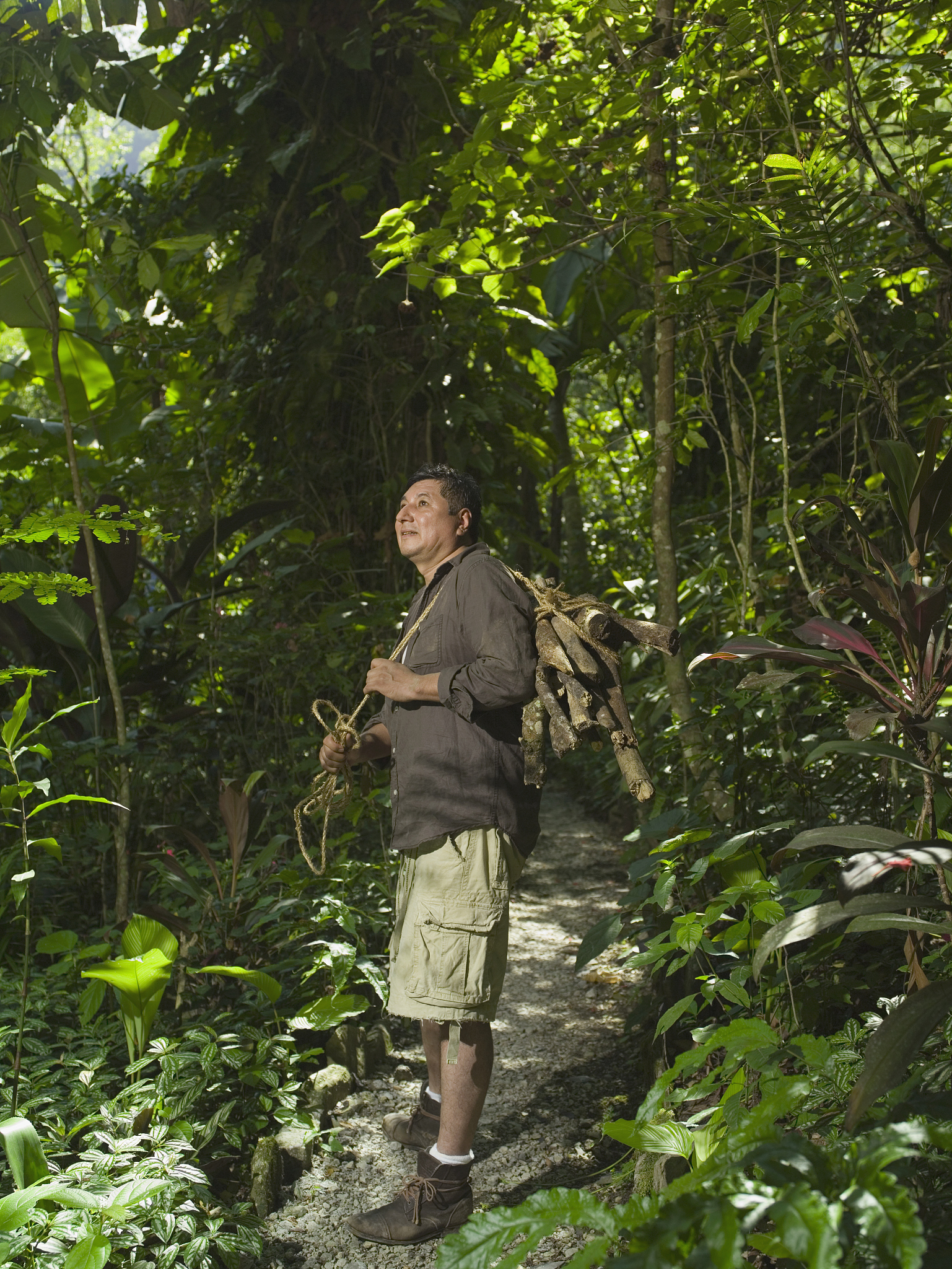 请用五百字帮我描写一下一位老婆婆带着一位年轻人和小孩儿下山然后在山脚下休息的画面