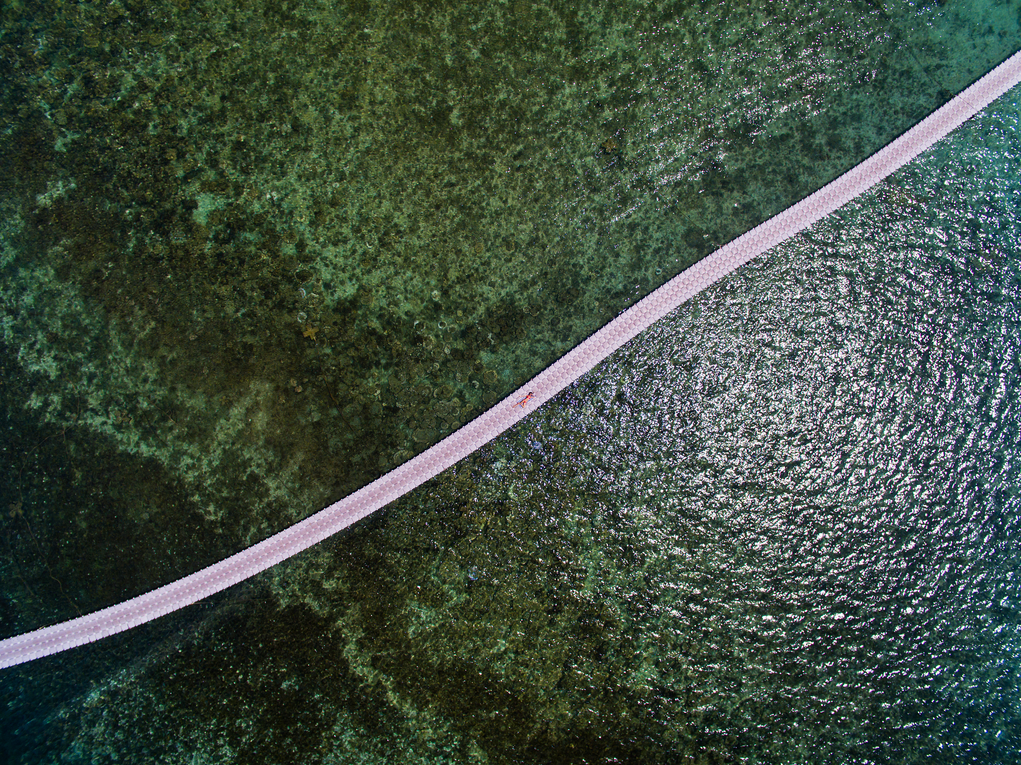 aerial view woman in red swimsuit on a pontoon bridge