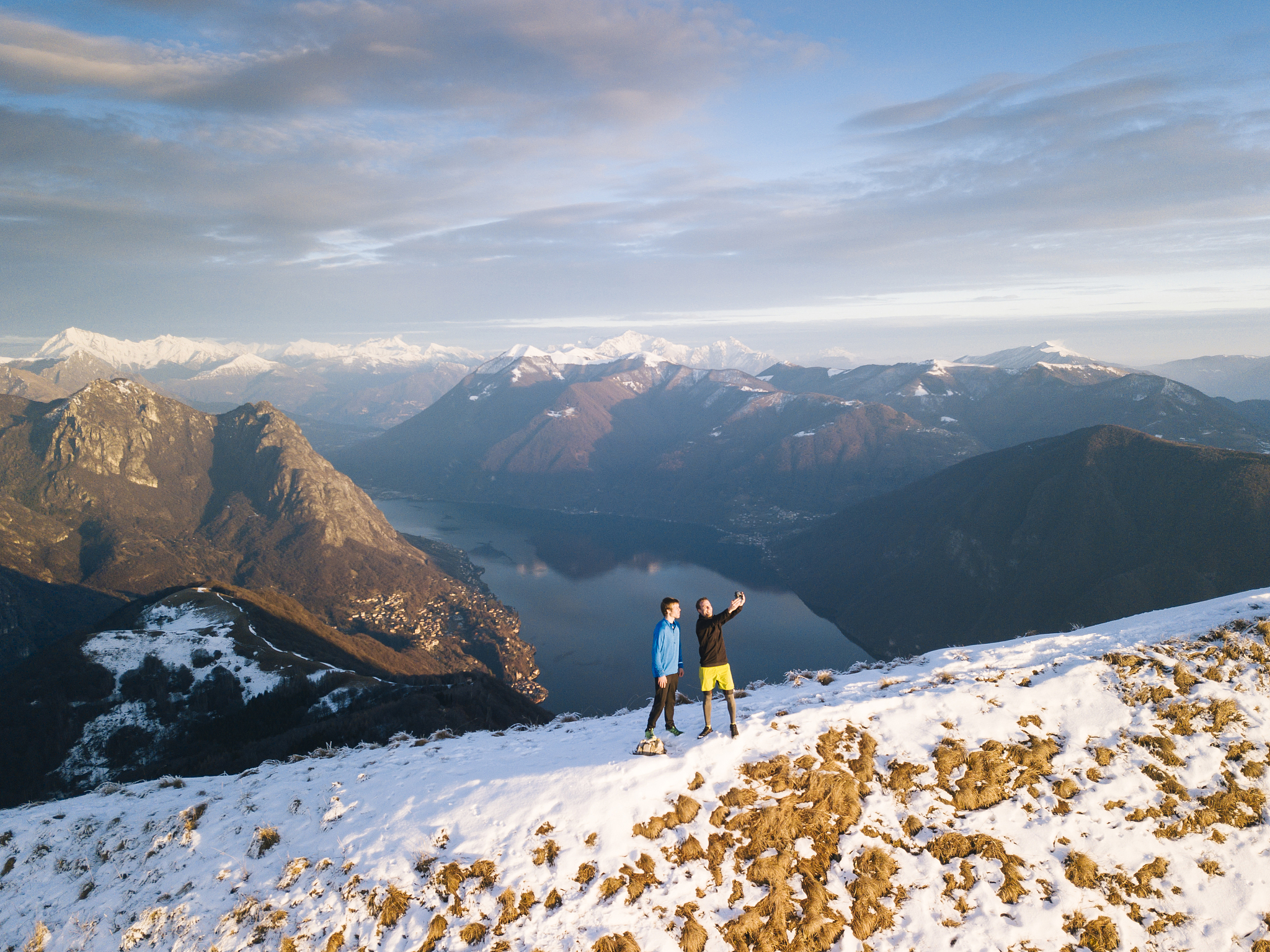 trail runners take pic from ridge, above lake, valley