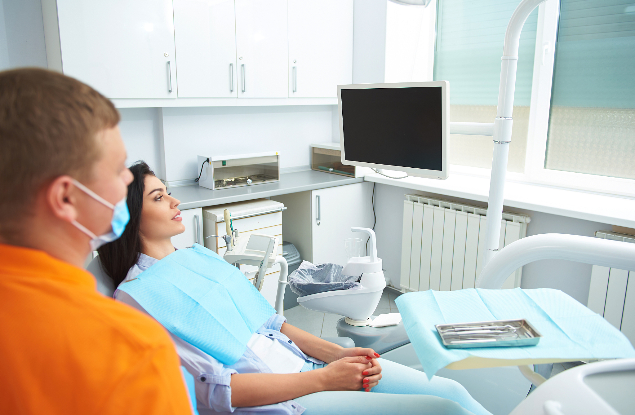 happy woman and dentist looking at the screen