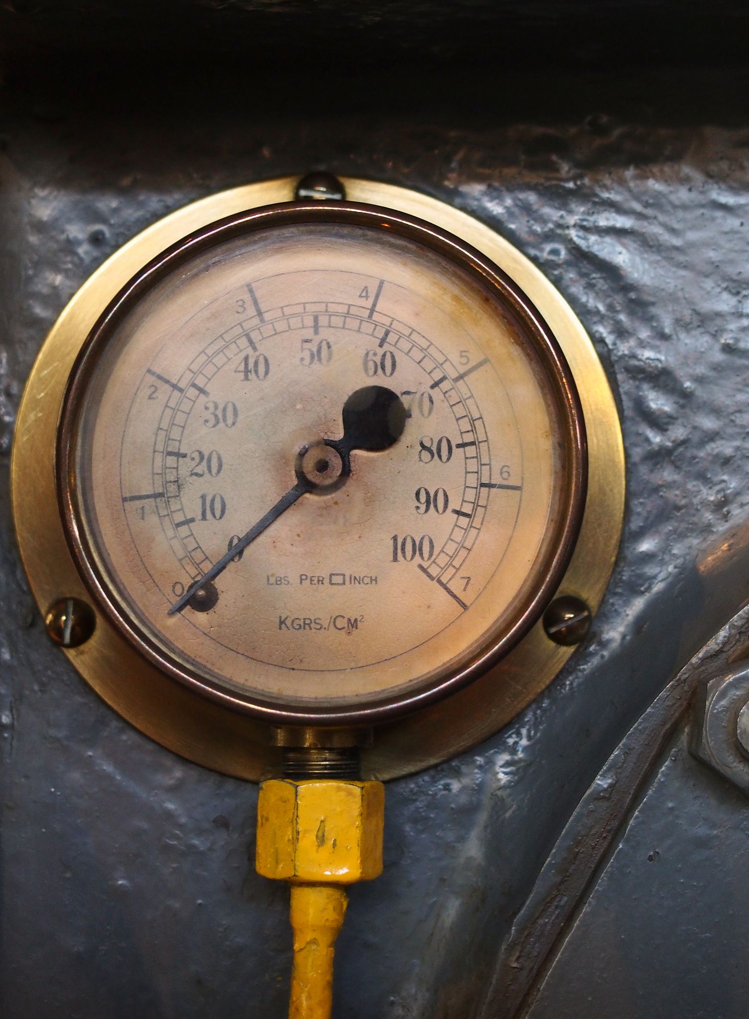 an old brass pressure meter with a round scale with numbers on a