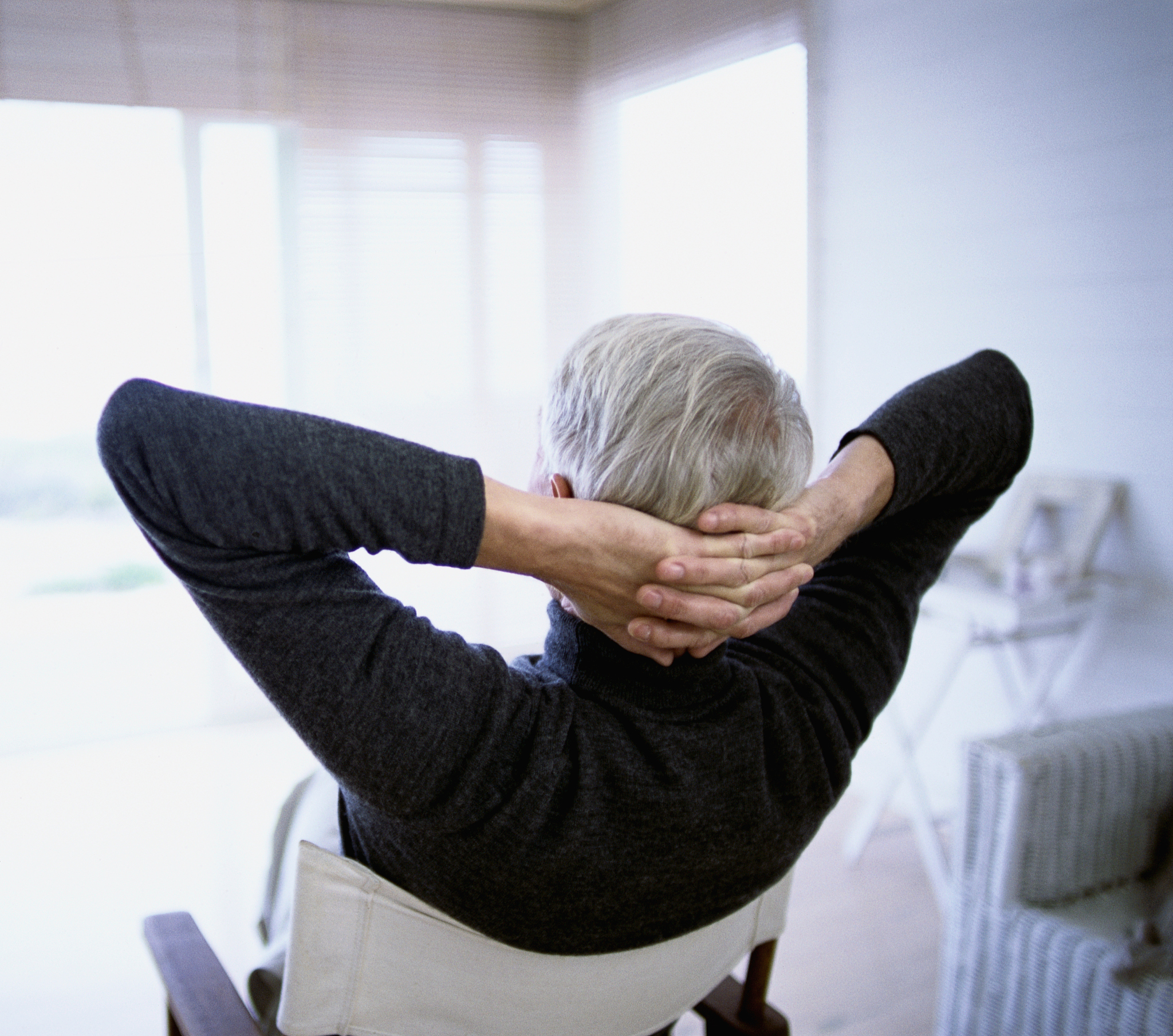 senior man with arms behind his head