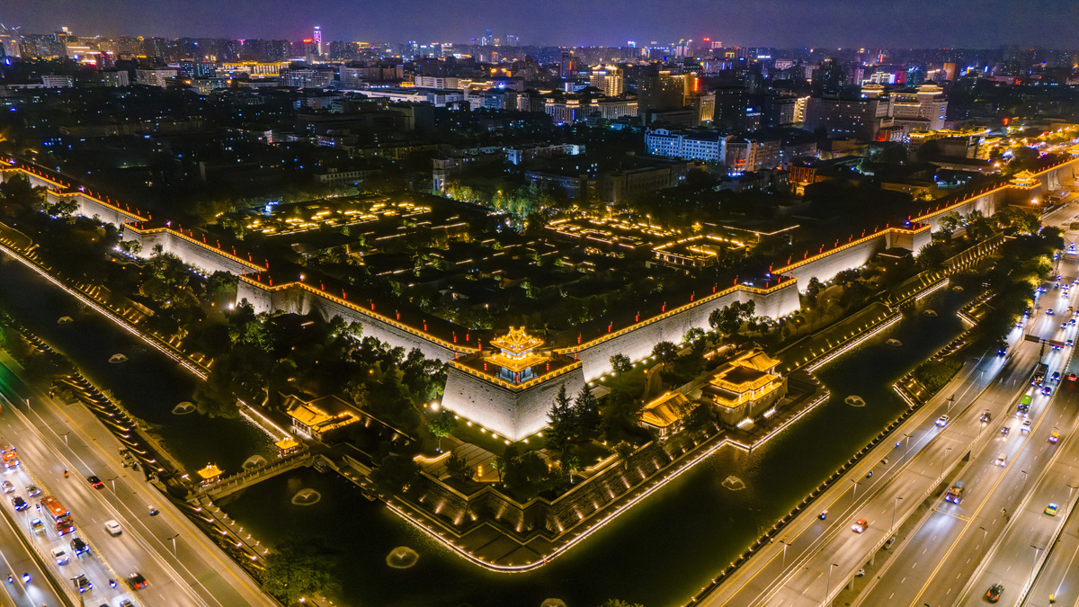 西安古城墙夜景:明代堡垒灯火辉煌,现代高速公路交通