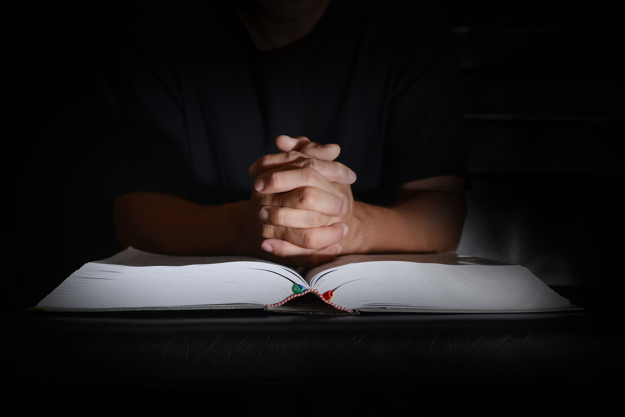 midsection of person with book against black background
