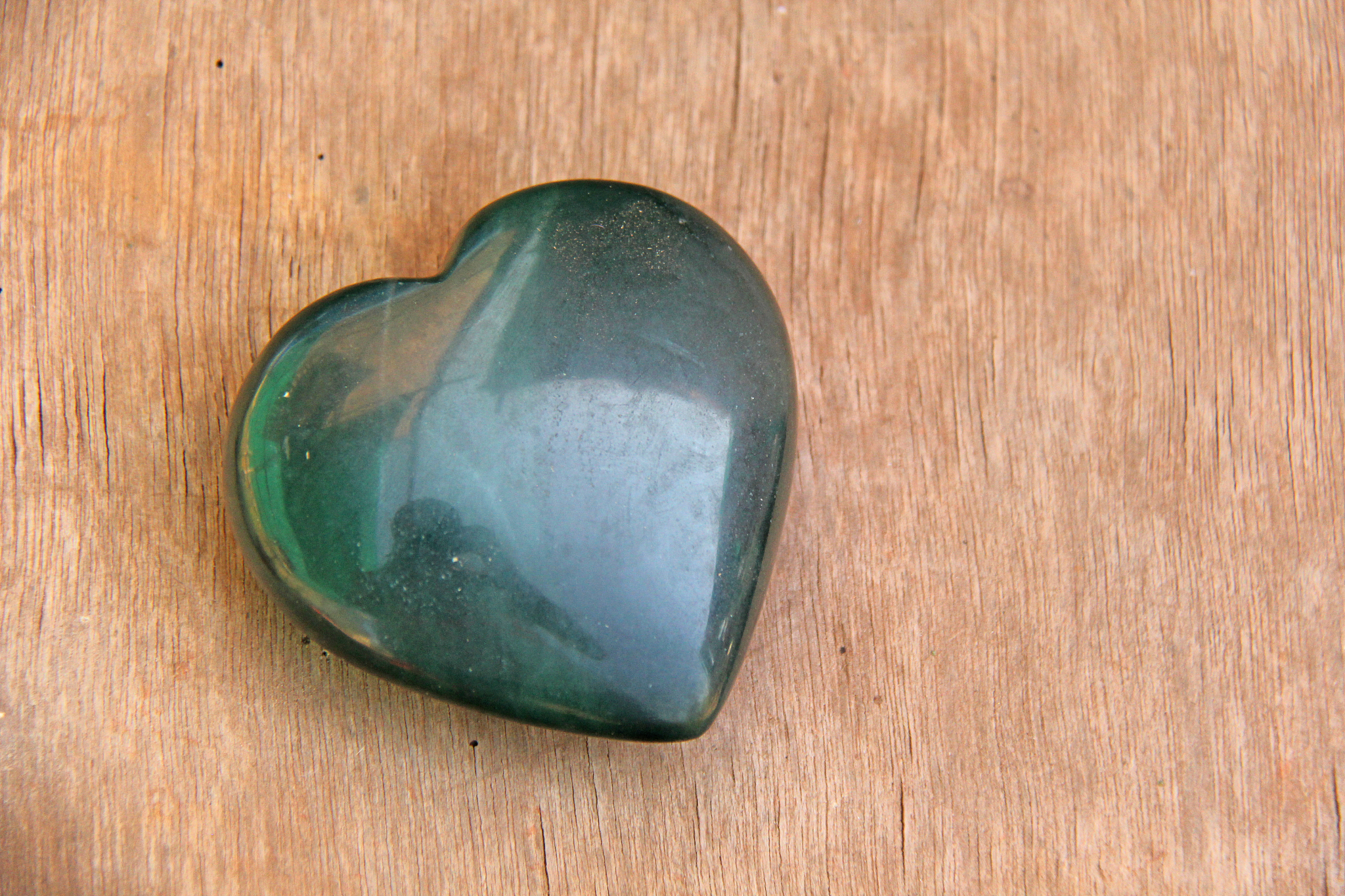 green heart made of natural stone jade. a heart shaped stone lie