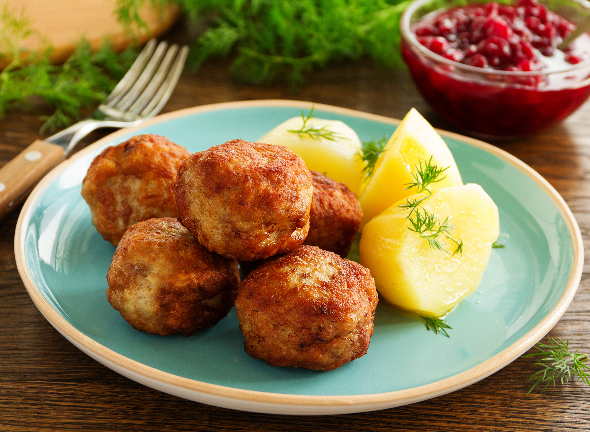 hot meatballs with boiled potatoes and cranberry sauce ..