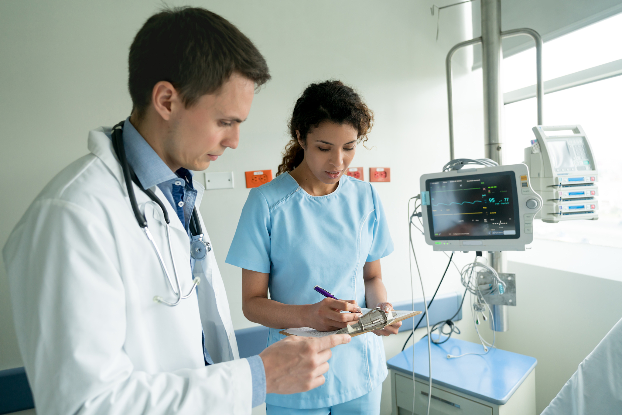nurse and doctor checking the medical chart of a patient both lo