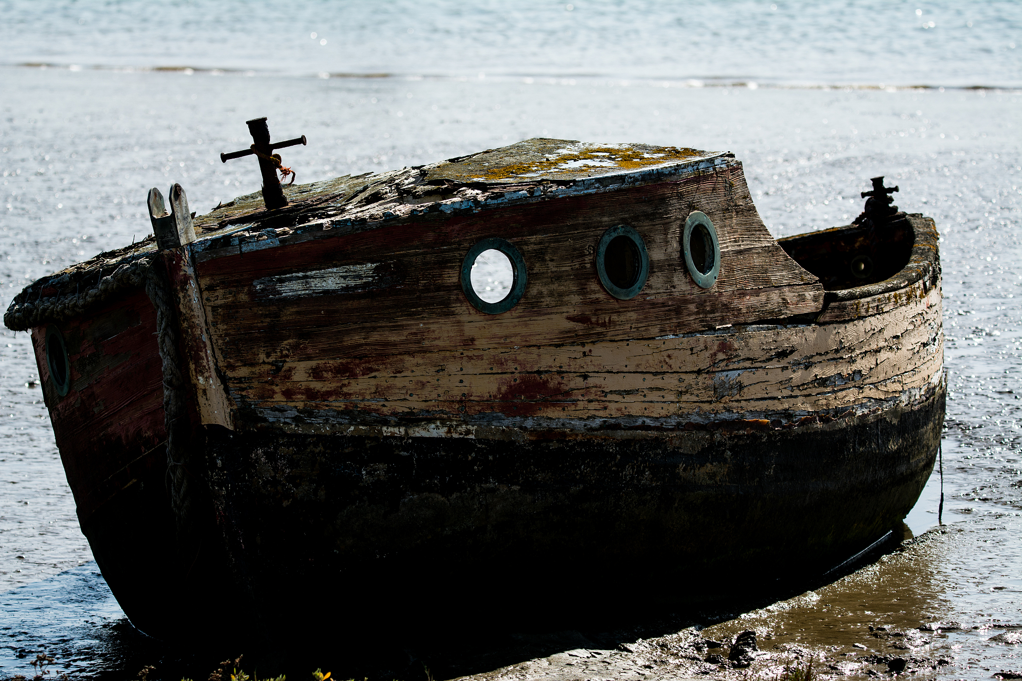 old boat moored on sea shore