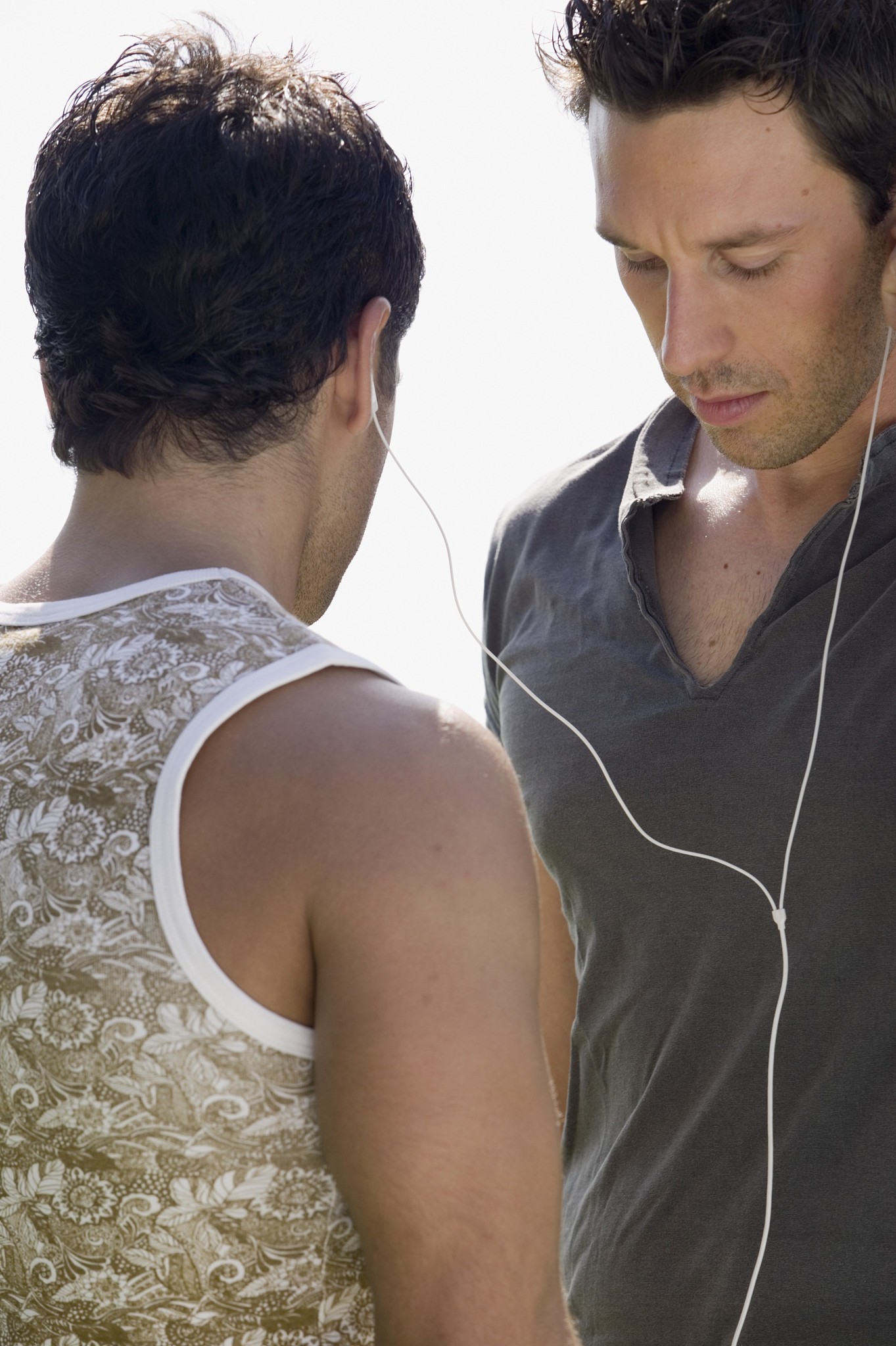 two young men sharing mp3 player