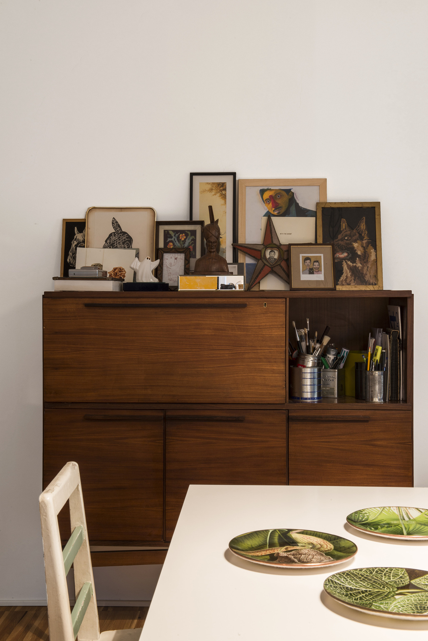 photos on high sideboard with dining table in foreground