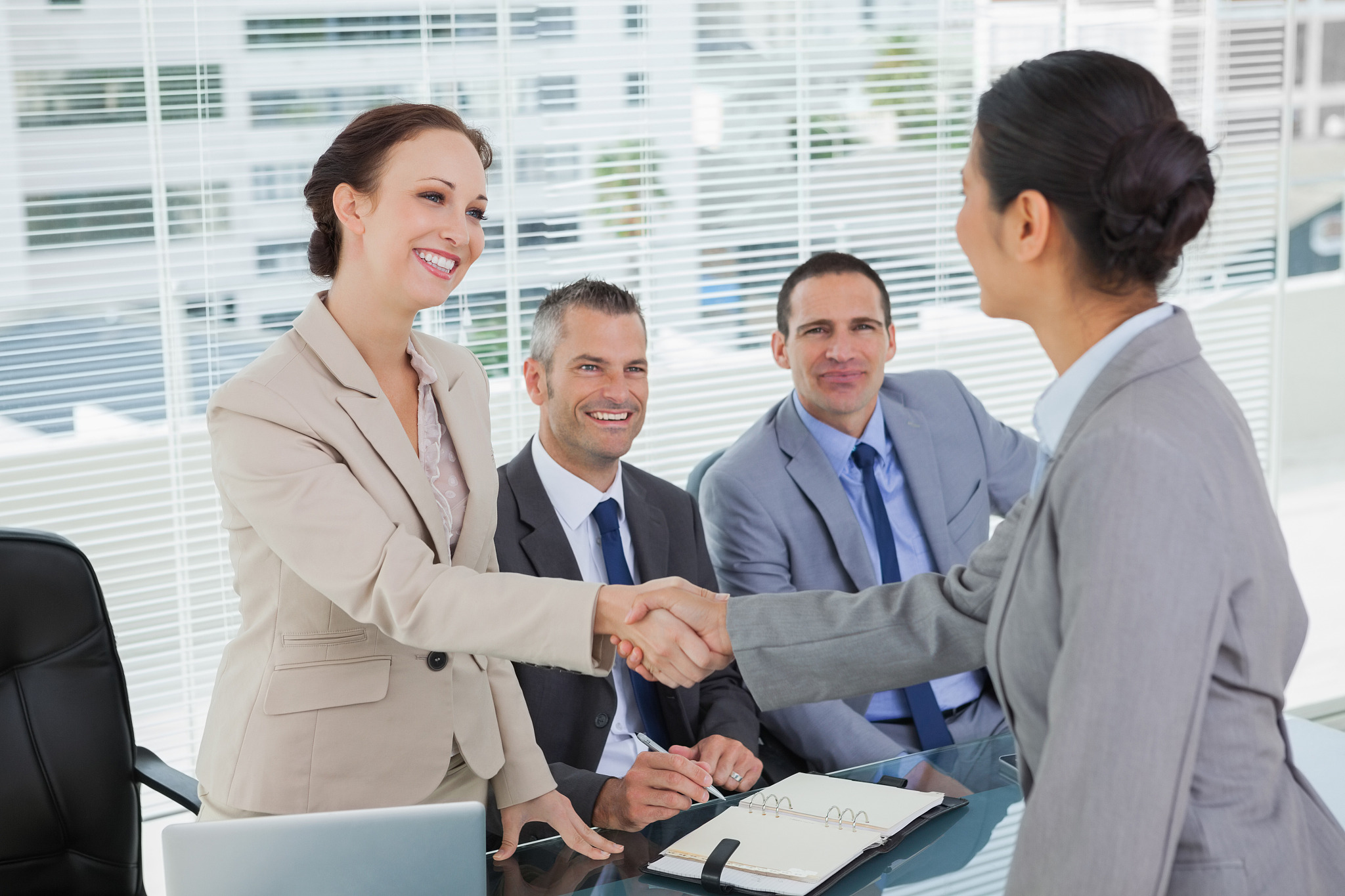 young pretty applicant shaking hands with future employers in br