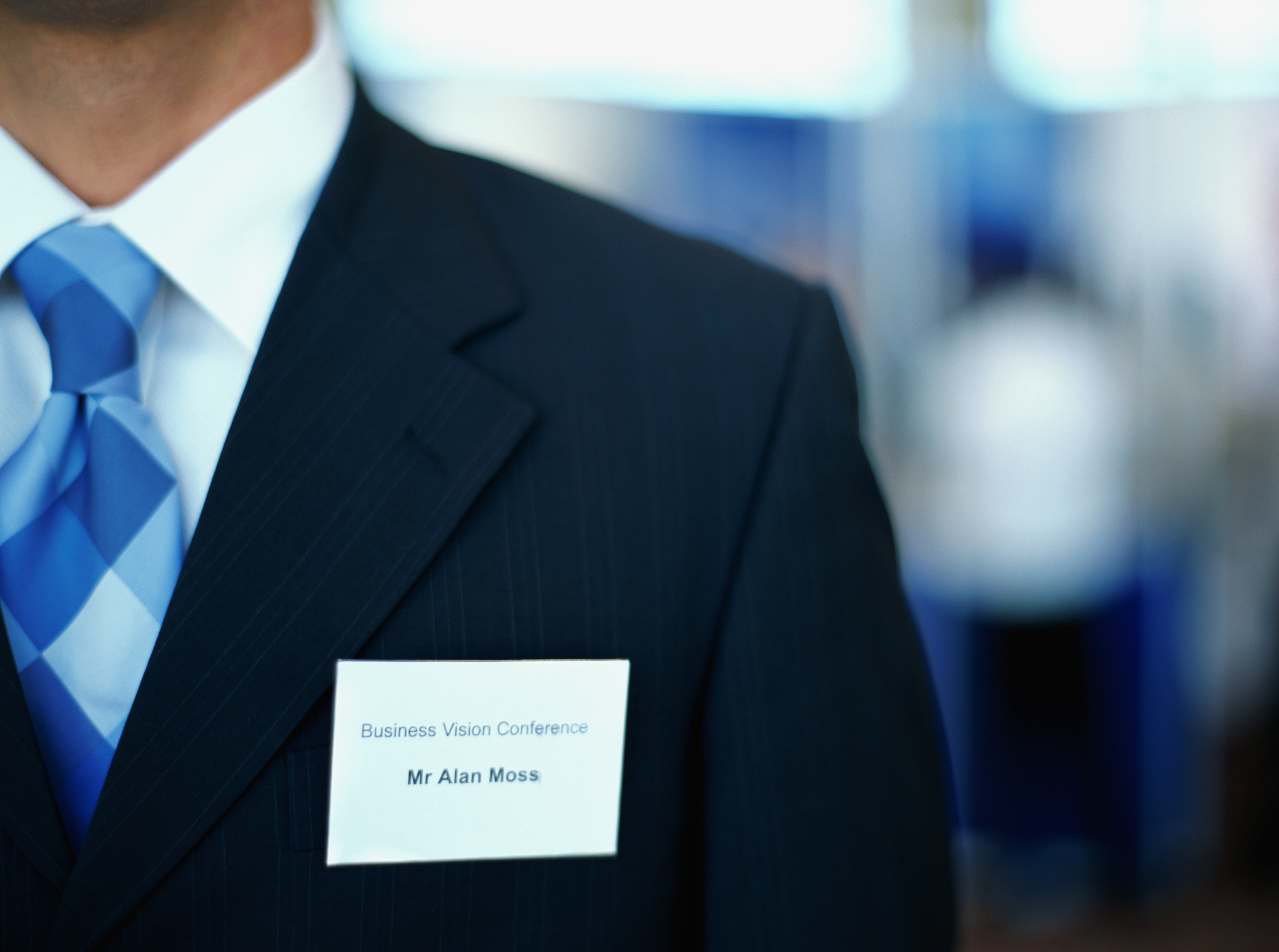 mid section view of a businessman wearing an id card on his suit