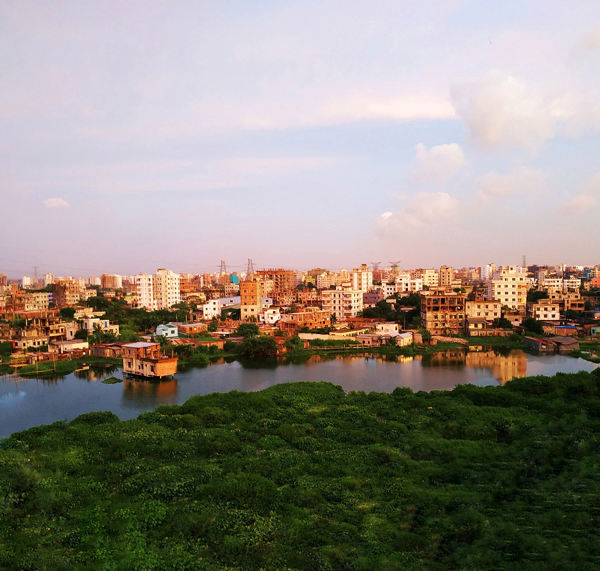 high angle view of buildings by river against sky
