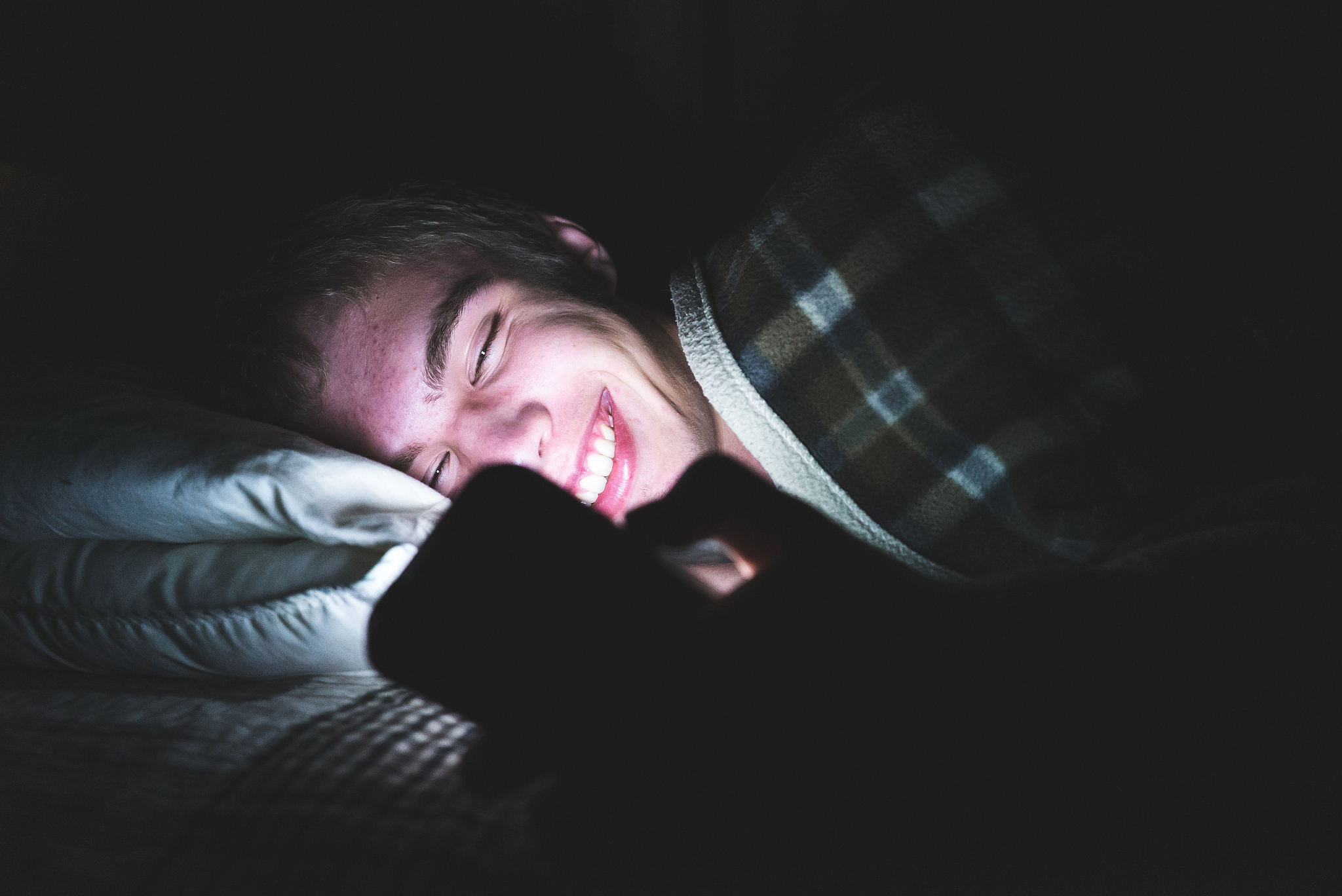 excited teenager watching a video in the dark.