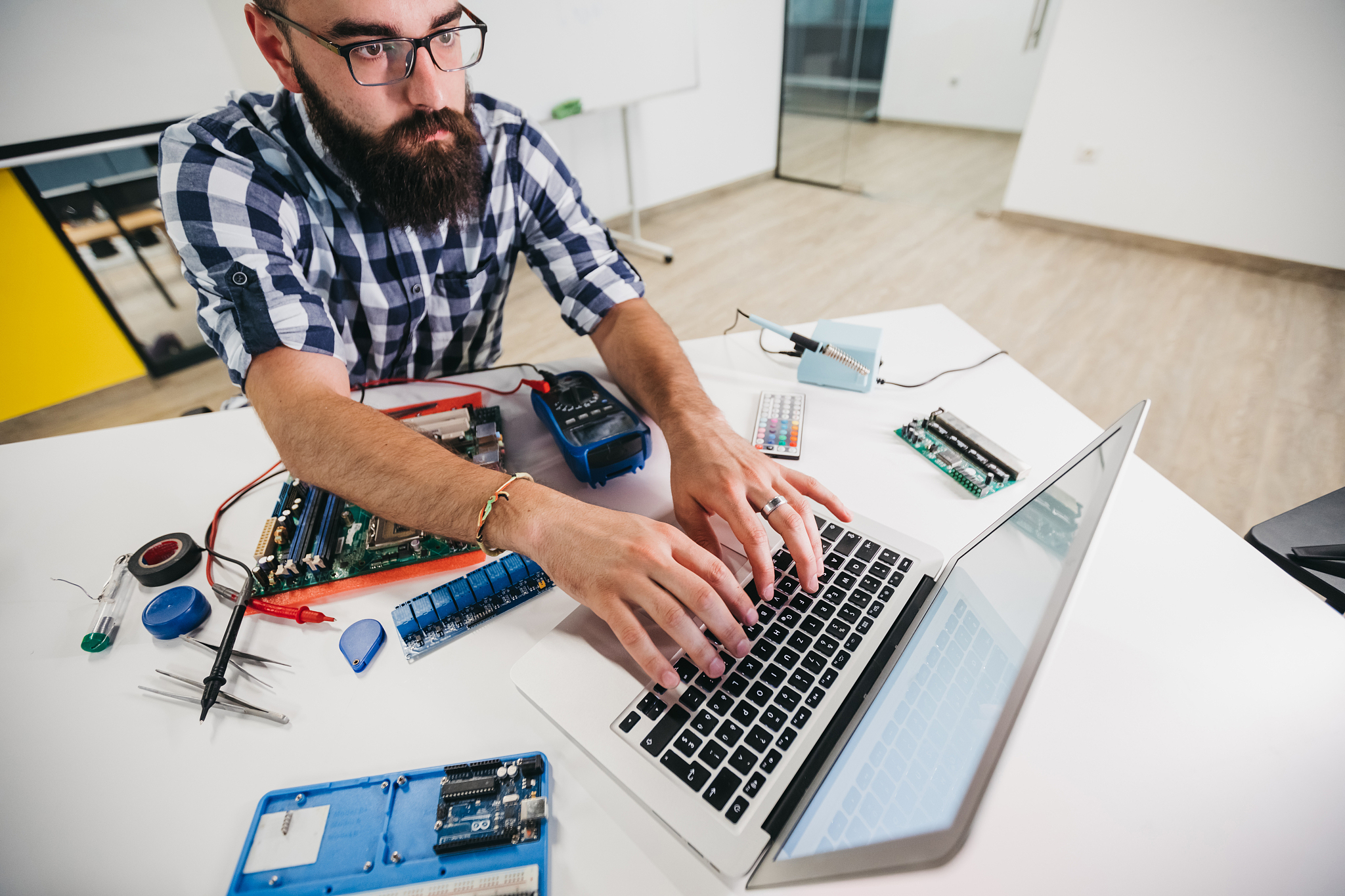 young man using computer while soldering
