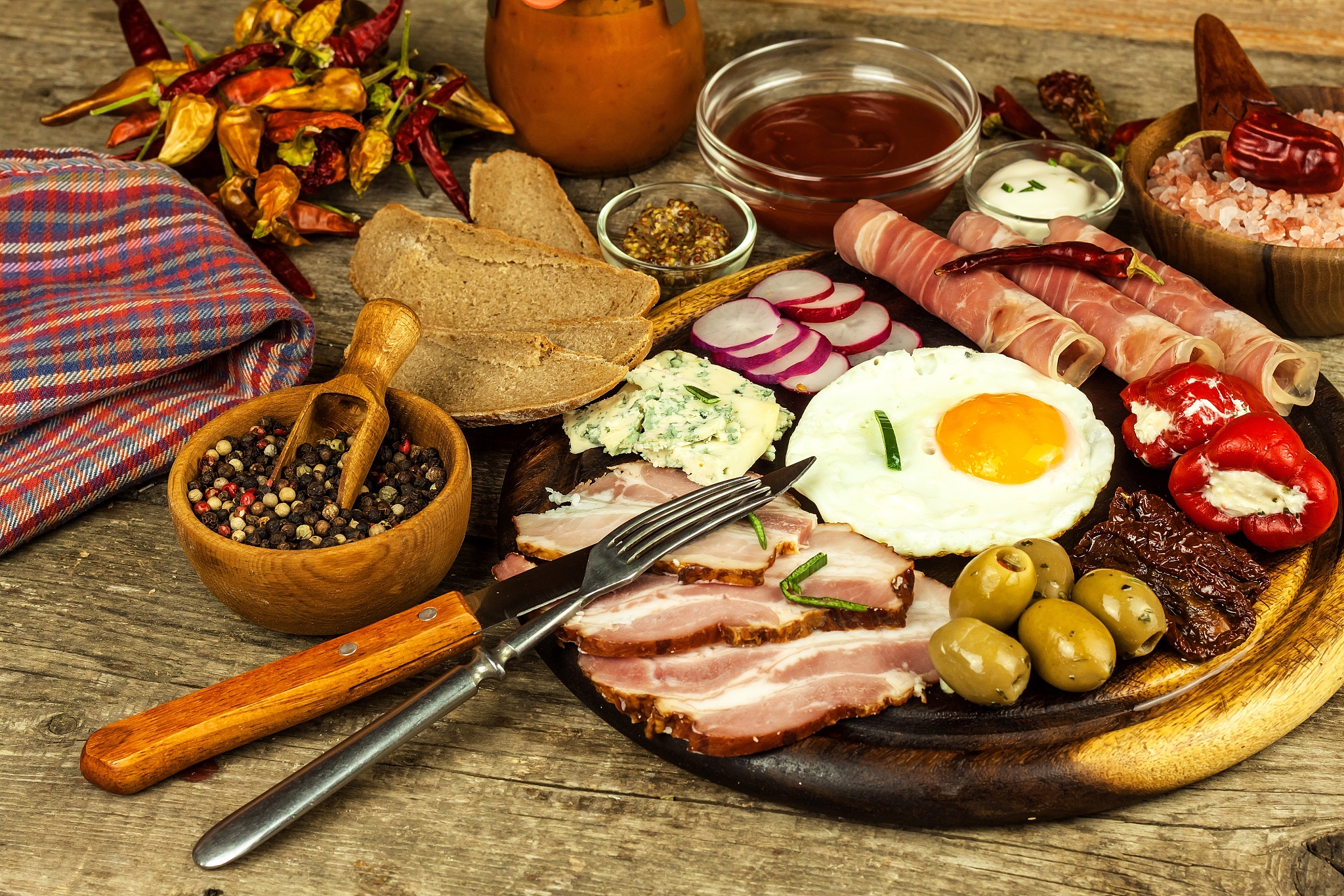 fried egg on a wooden board. a hearty breakfast with ham and veg