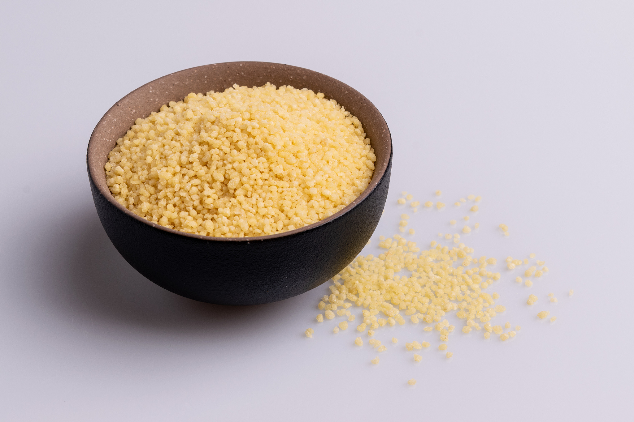 dry couscous isolated on white background, soft light, copy spac