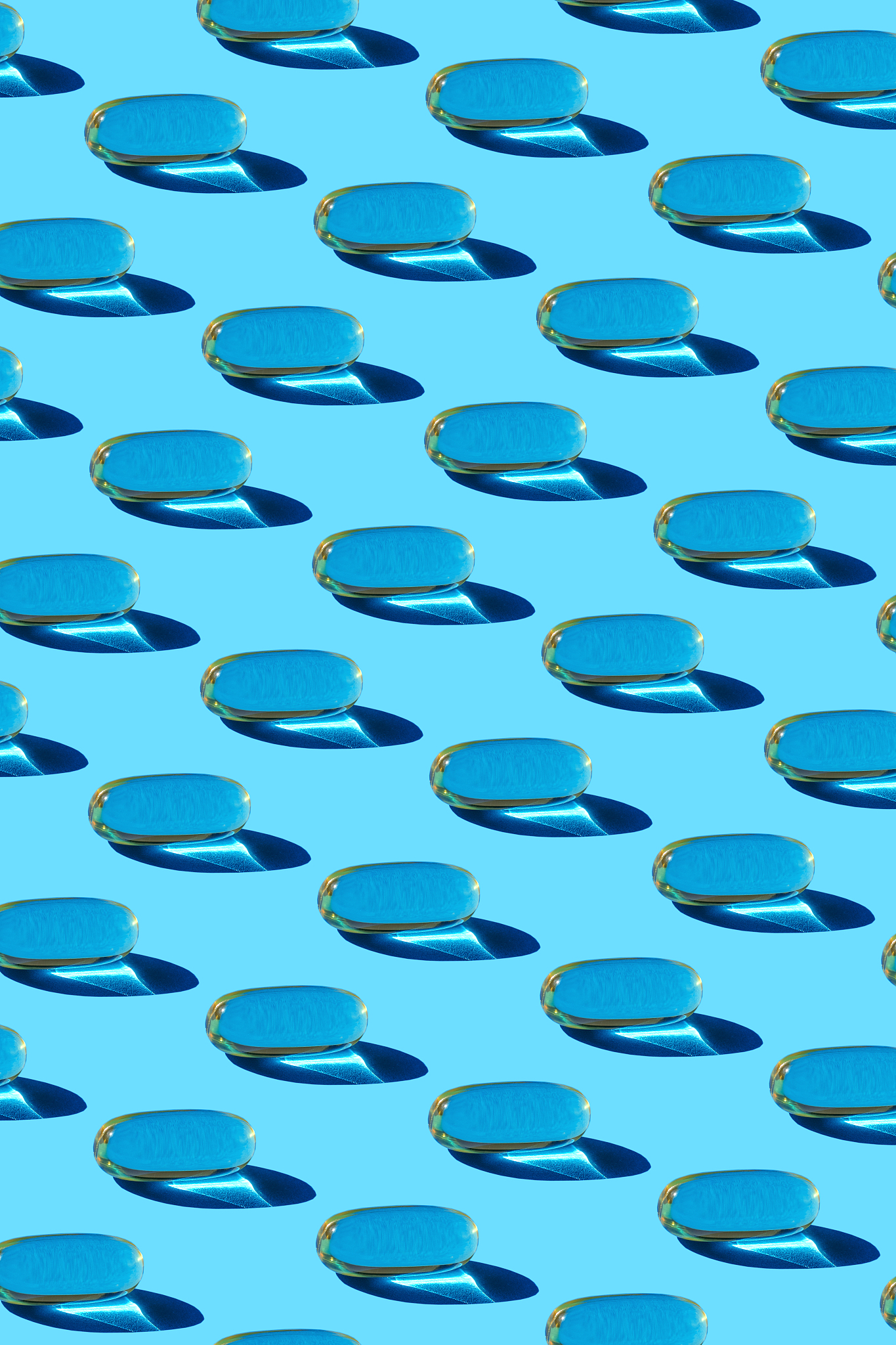 glass with fish oil pills on the blue background