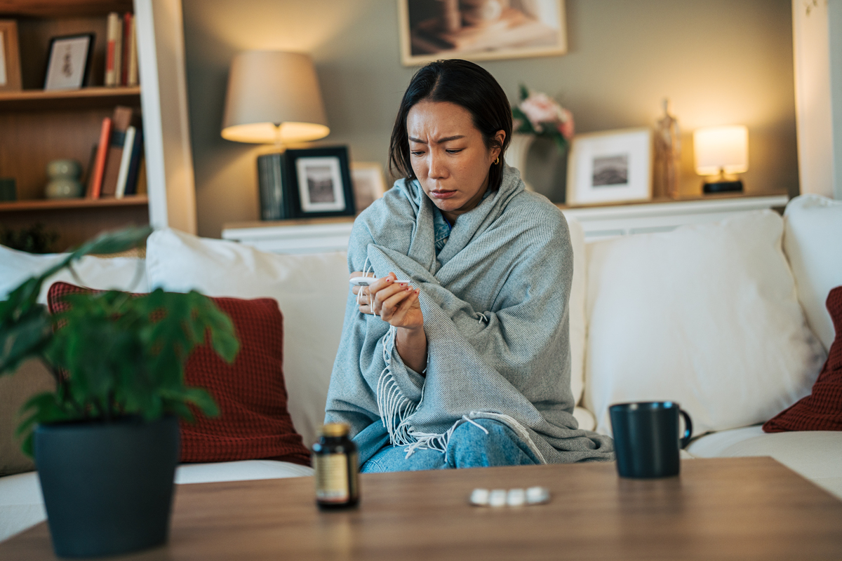 一名女子<strong>感觉</strong>不适,正用体温计测量体温