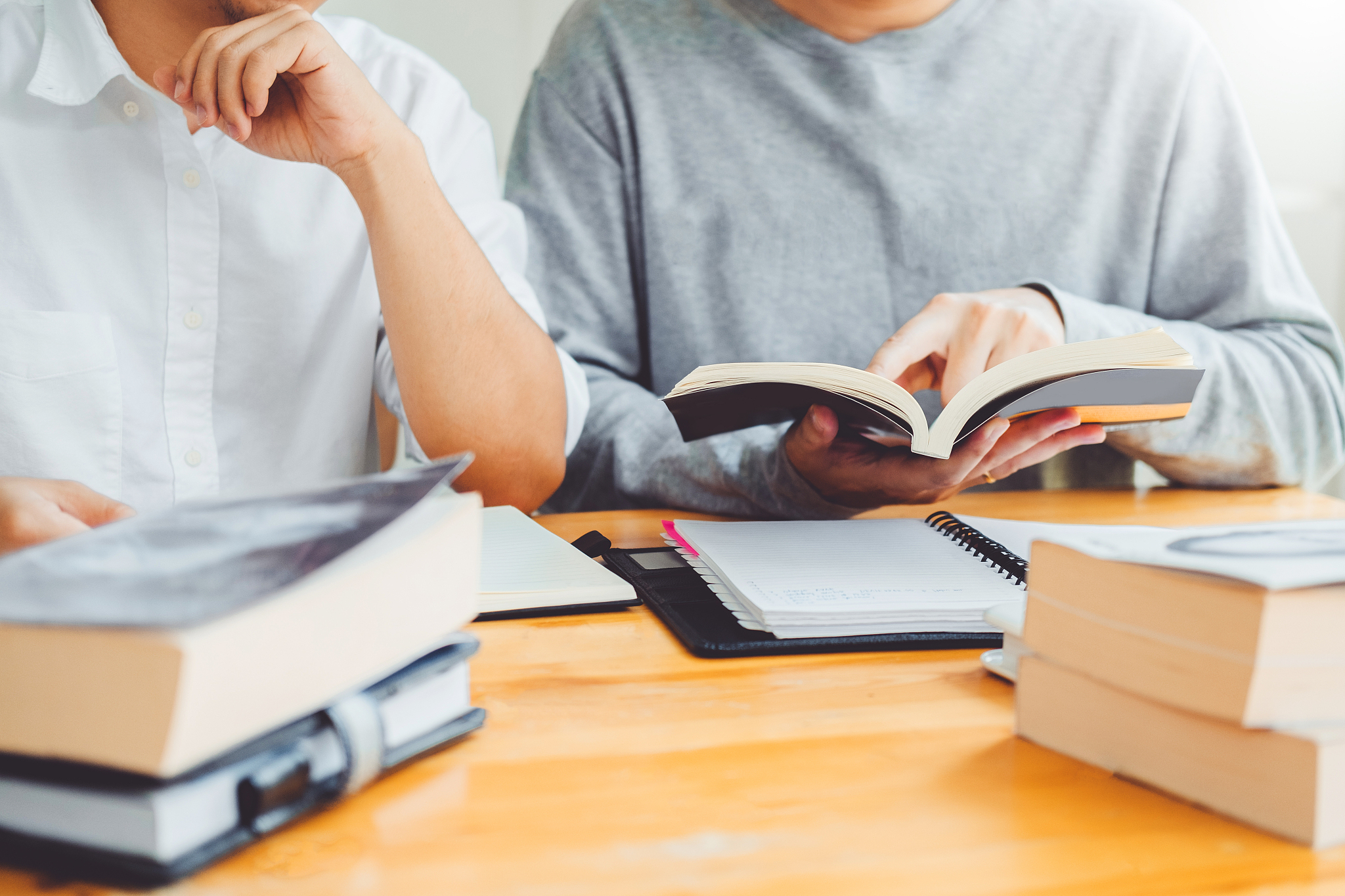 high school or college students studying and reading together in