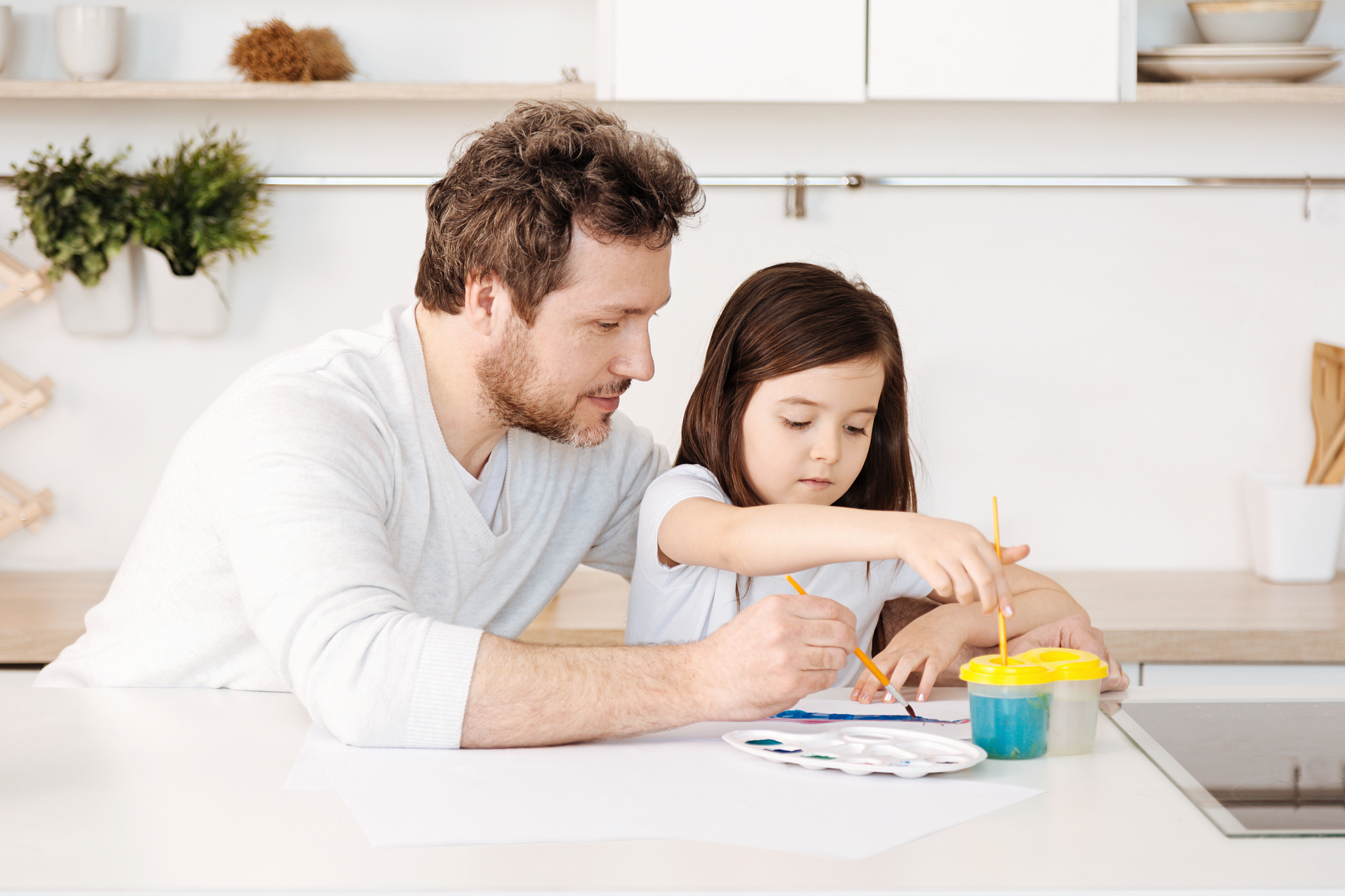 father and his daughter engaged in the painting process