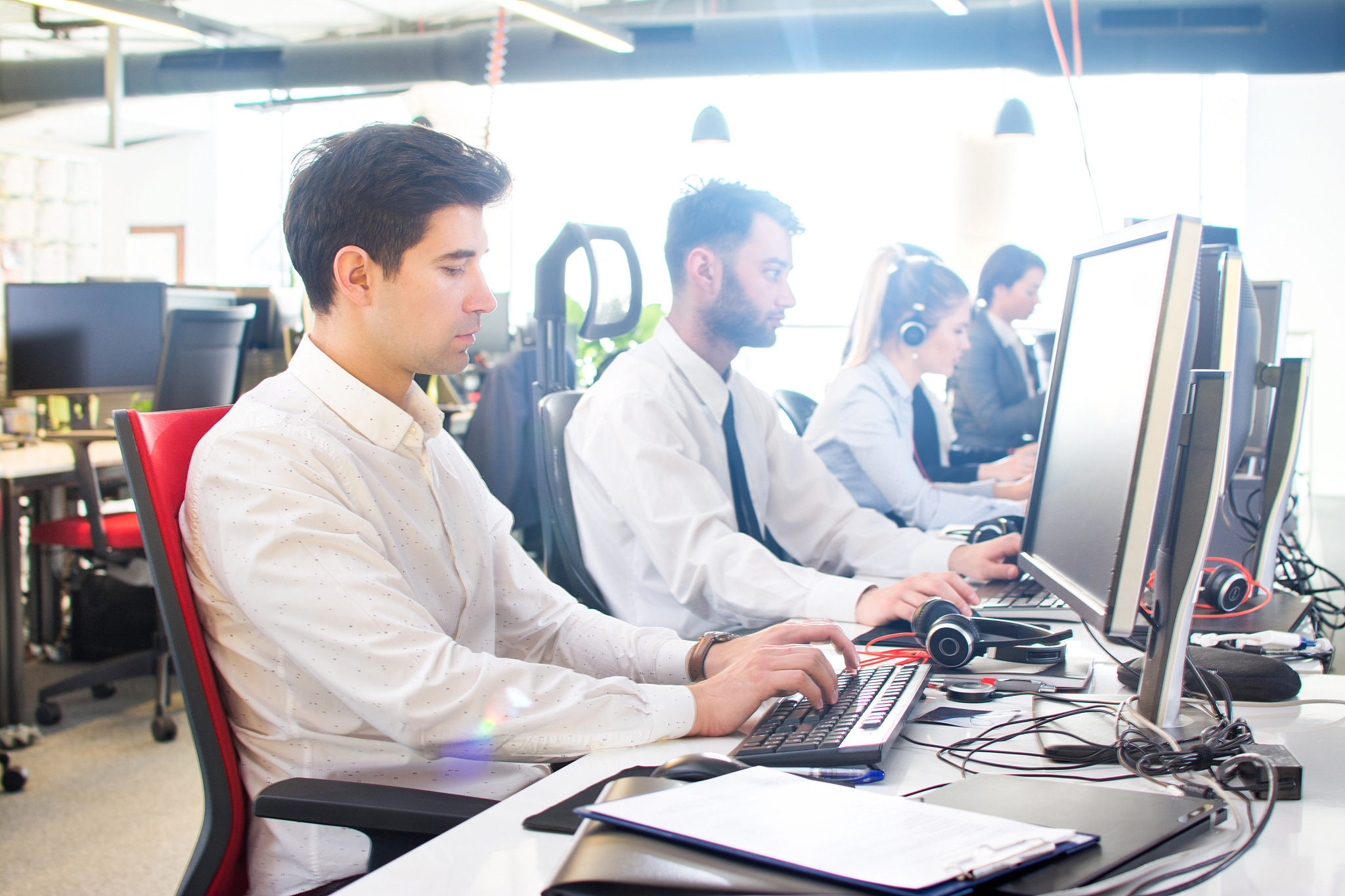 side view of business people working on computers at office.