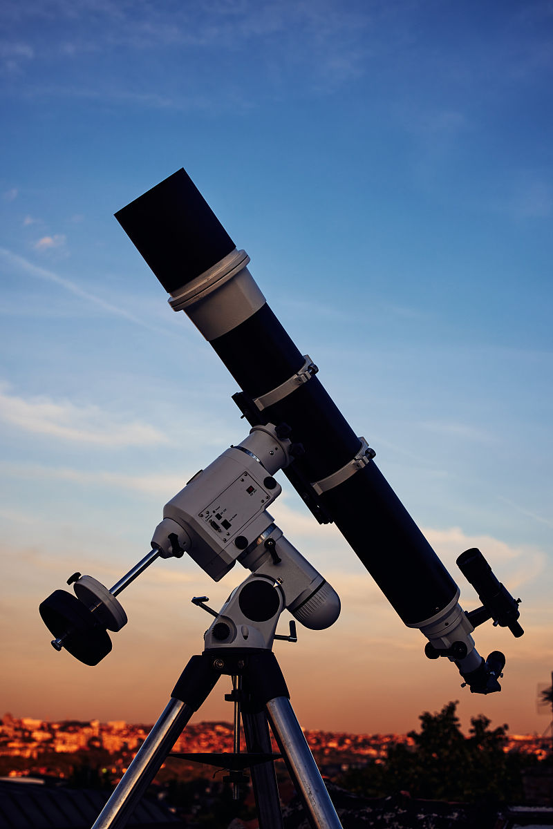 在黄昏的天空下,一个巨大的天文望远镜准备好观测星空.