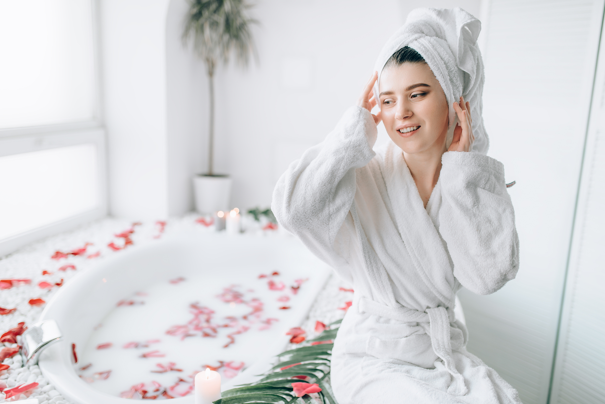 woman in bathroom decorated with rose petals