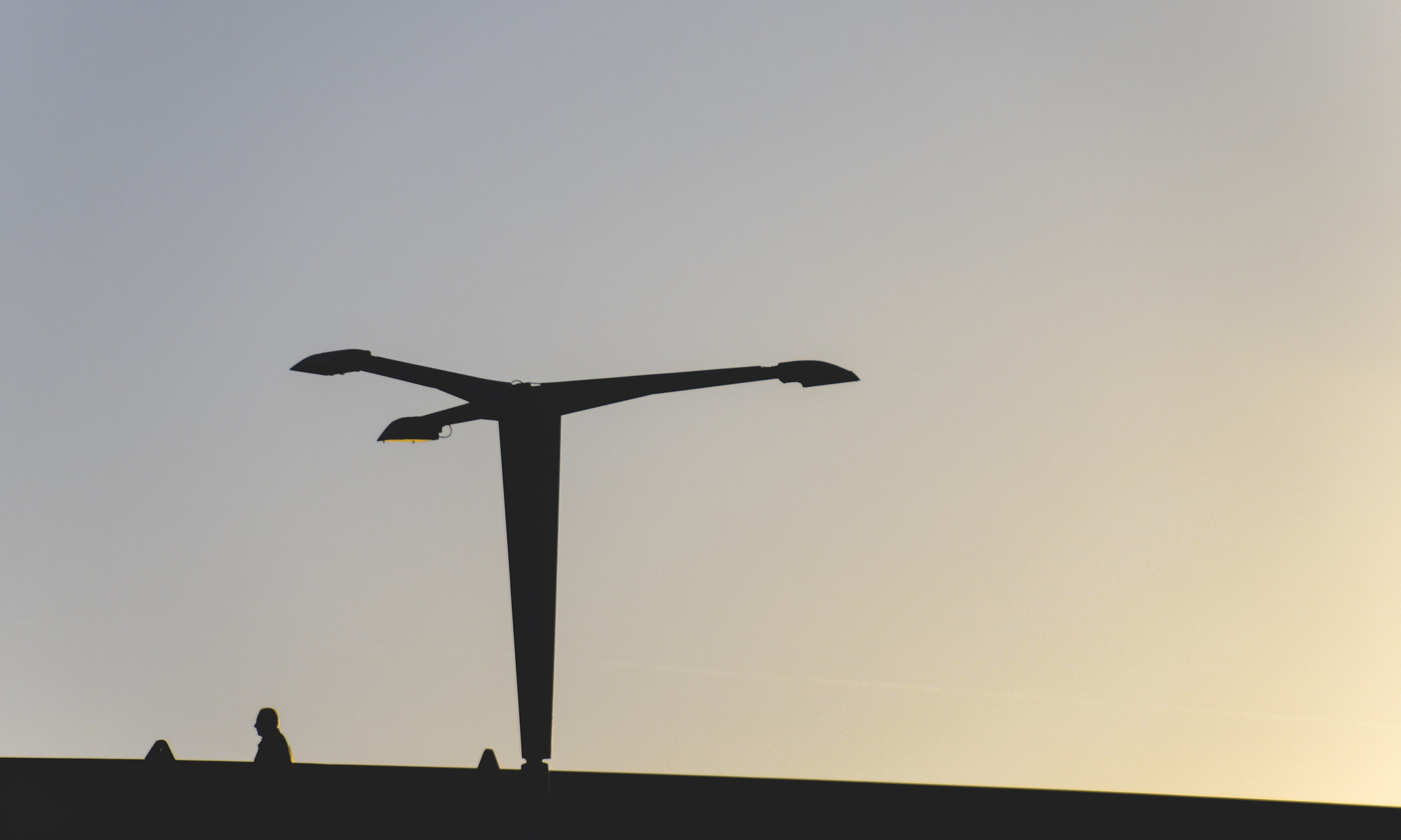 street light and a man silhouetted at sunset
