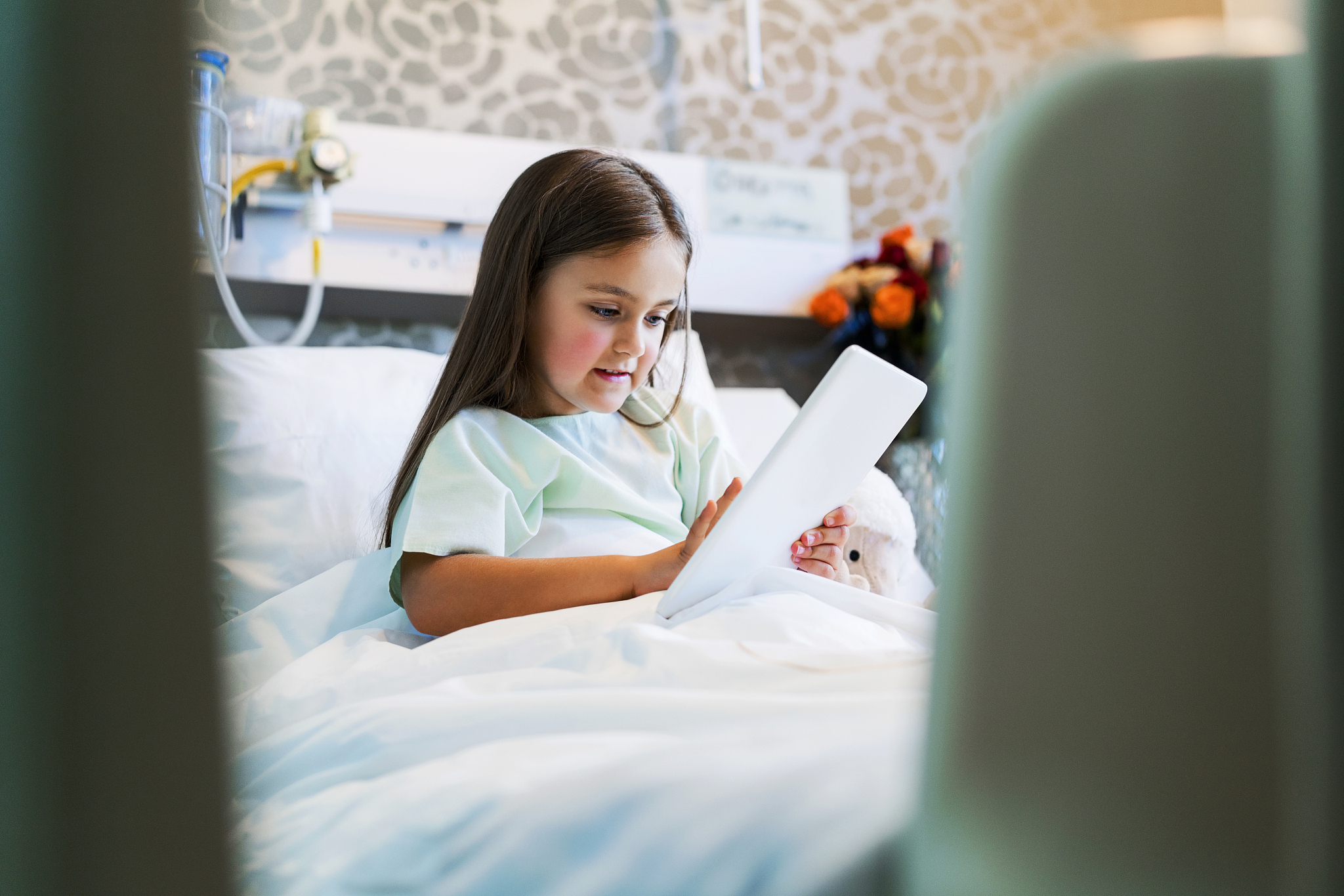 patient using digital tablet while lying on bed