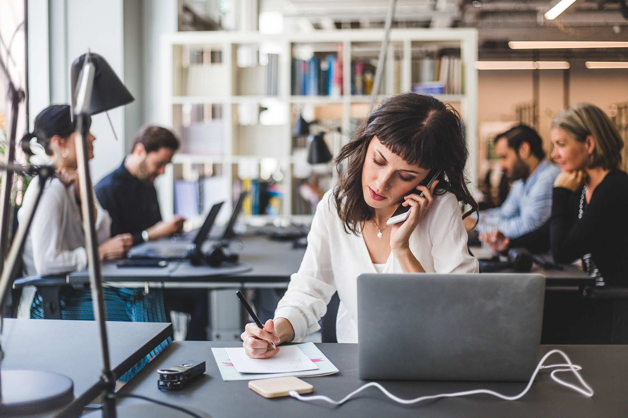 businesswoman talking on mobile phone while working at desk in c