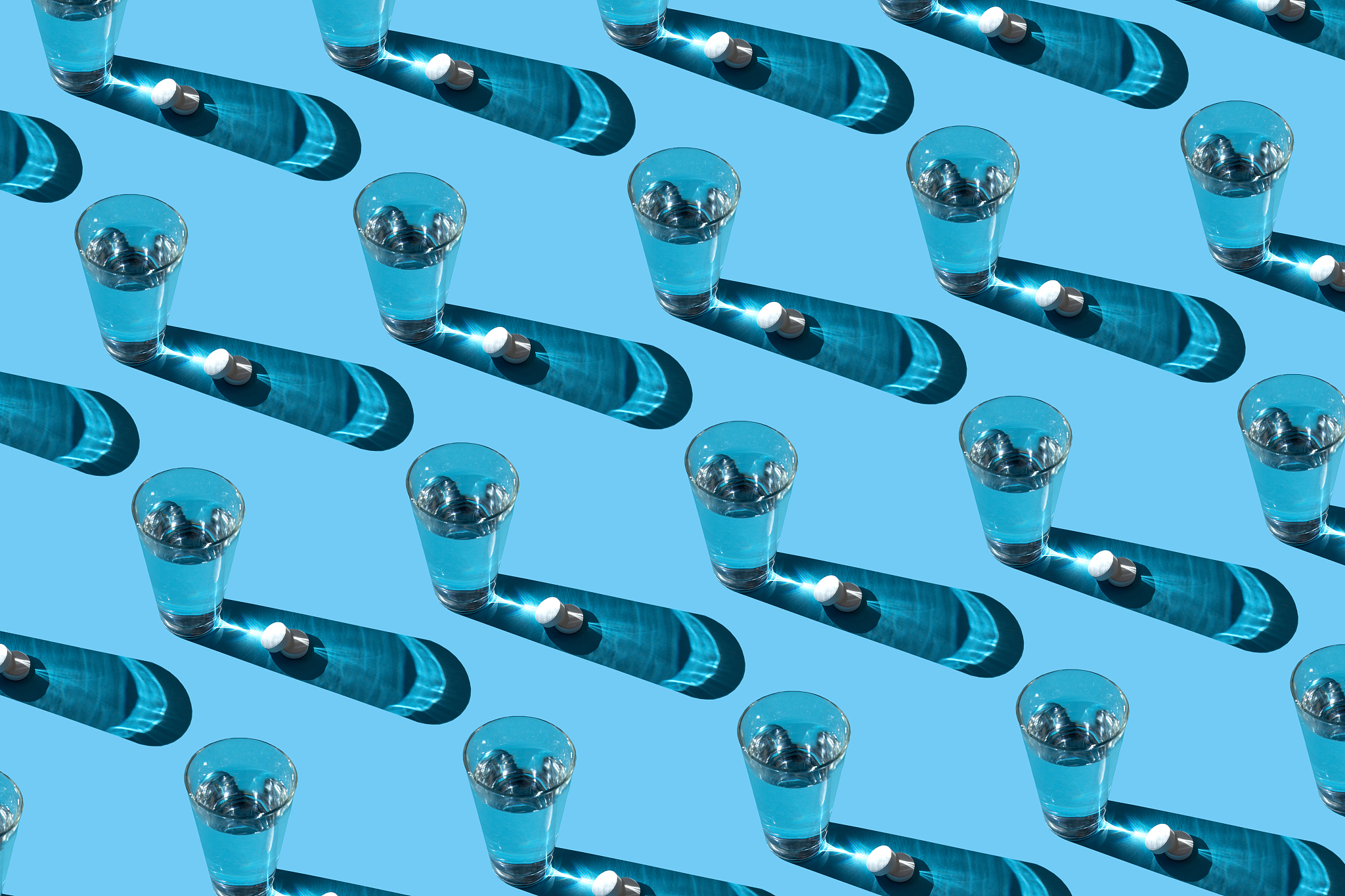 glasses with various pills on the blue background