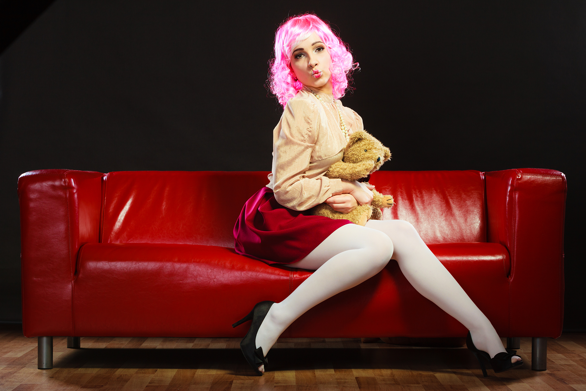 childlike woman and teddy bear sitting on couch