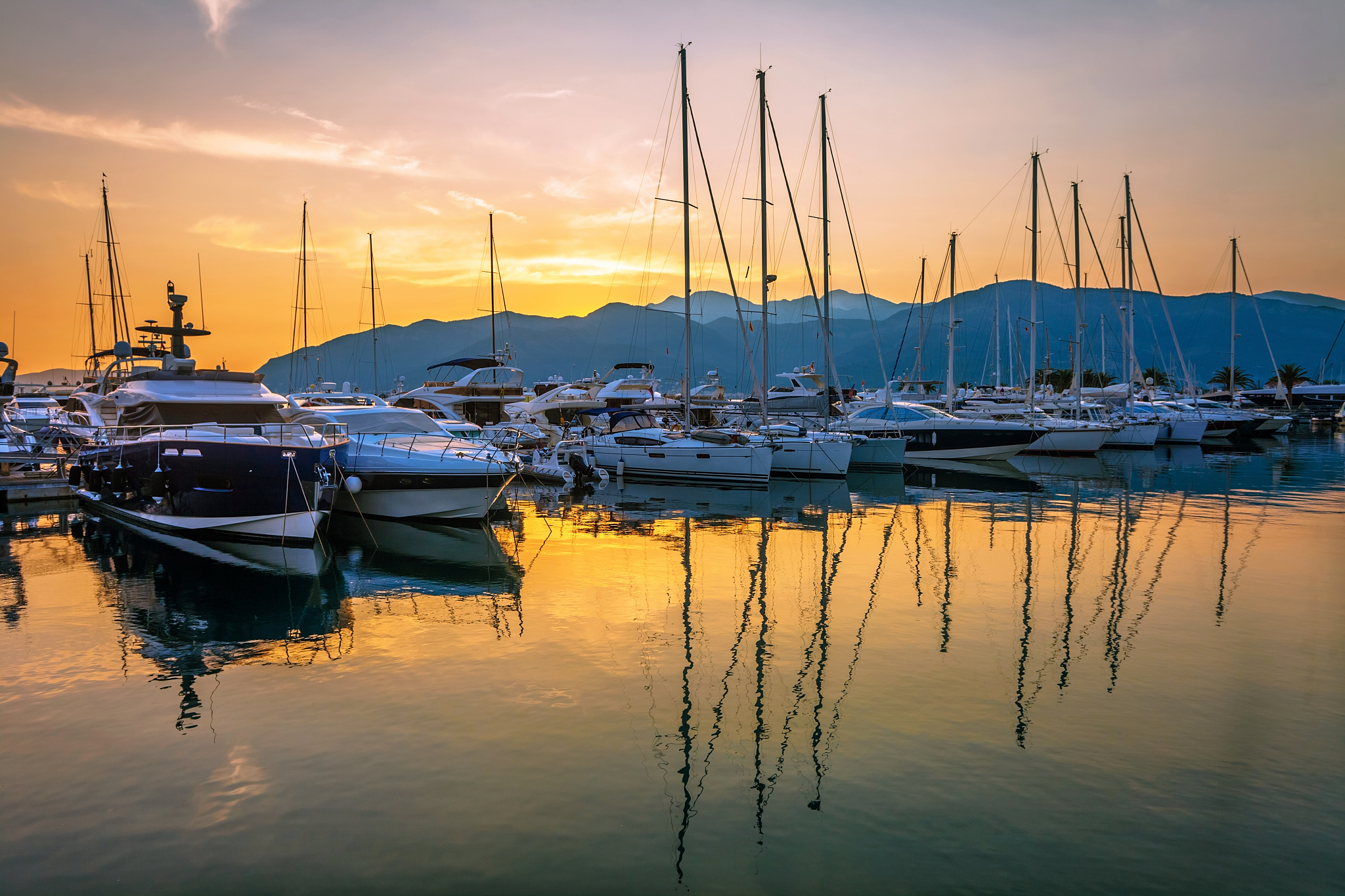 sailing boats in marina at sunset.