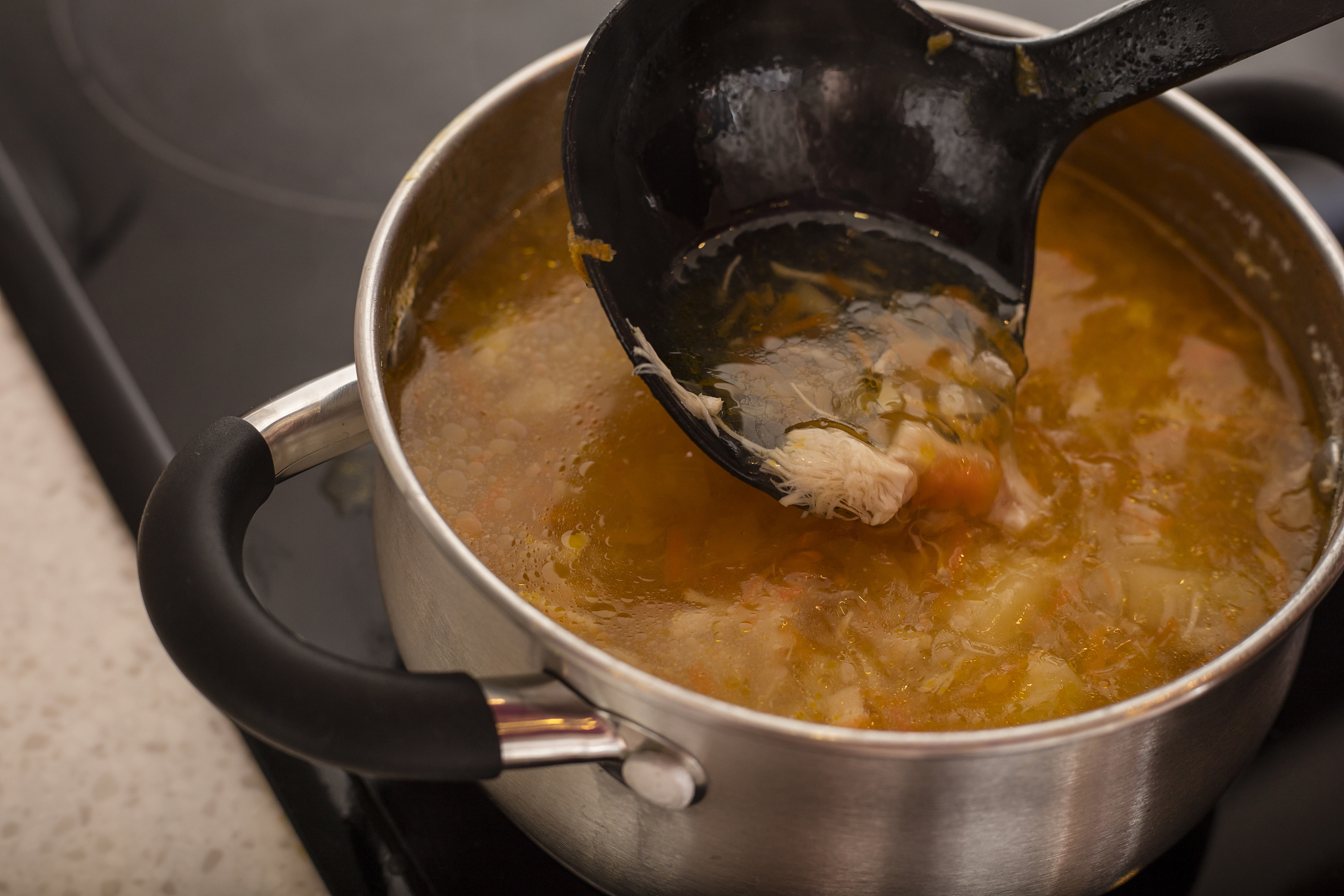 chicken soup in a saucepan on the stove. cooking food