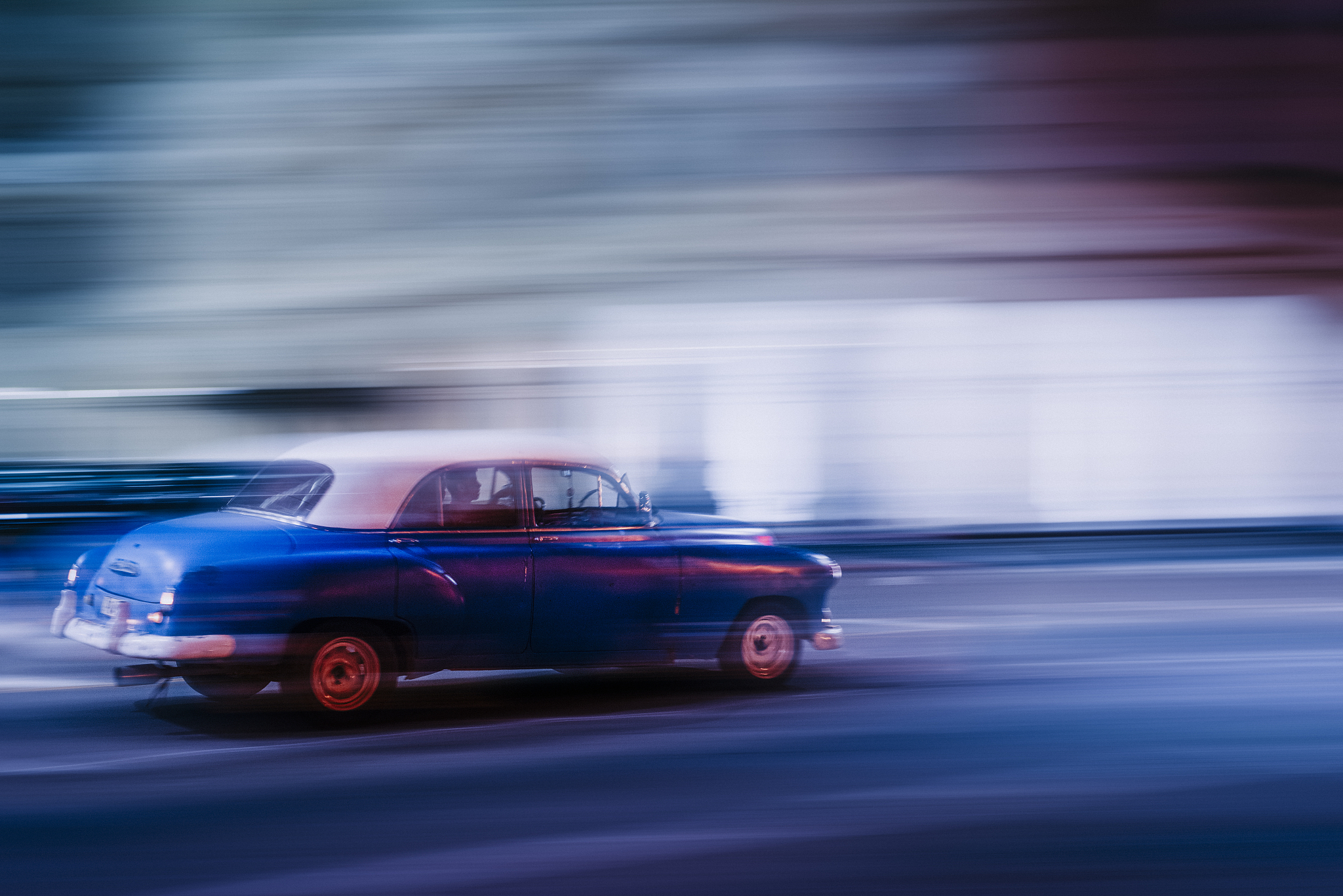 abstract view of motion blurred old american 1950s car drives by