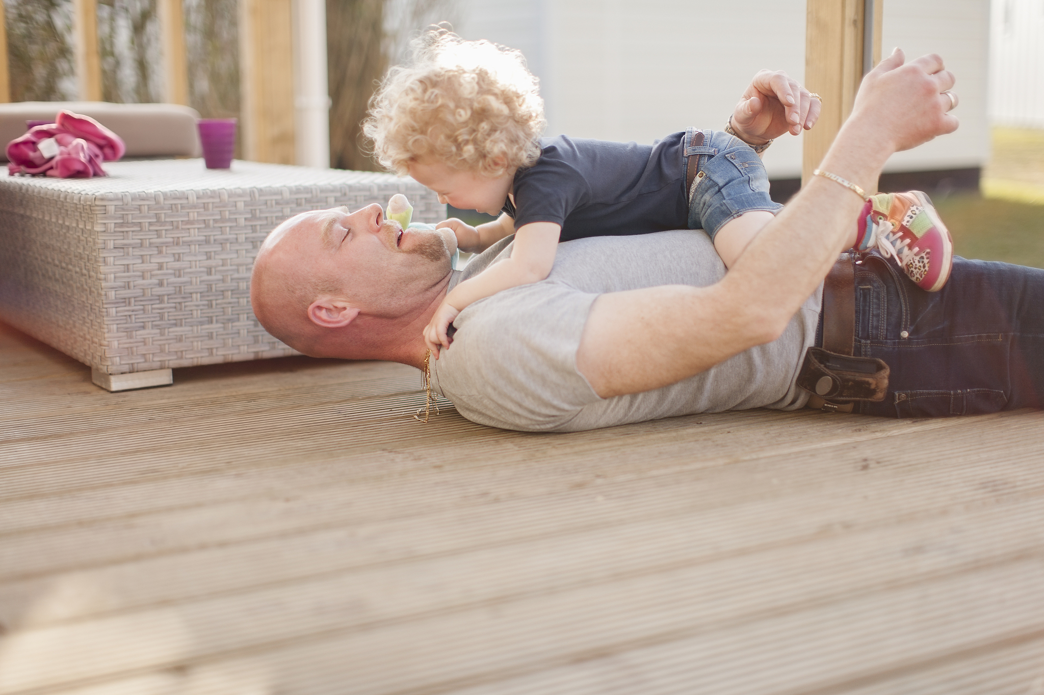 father playing with little daughter on terrace
