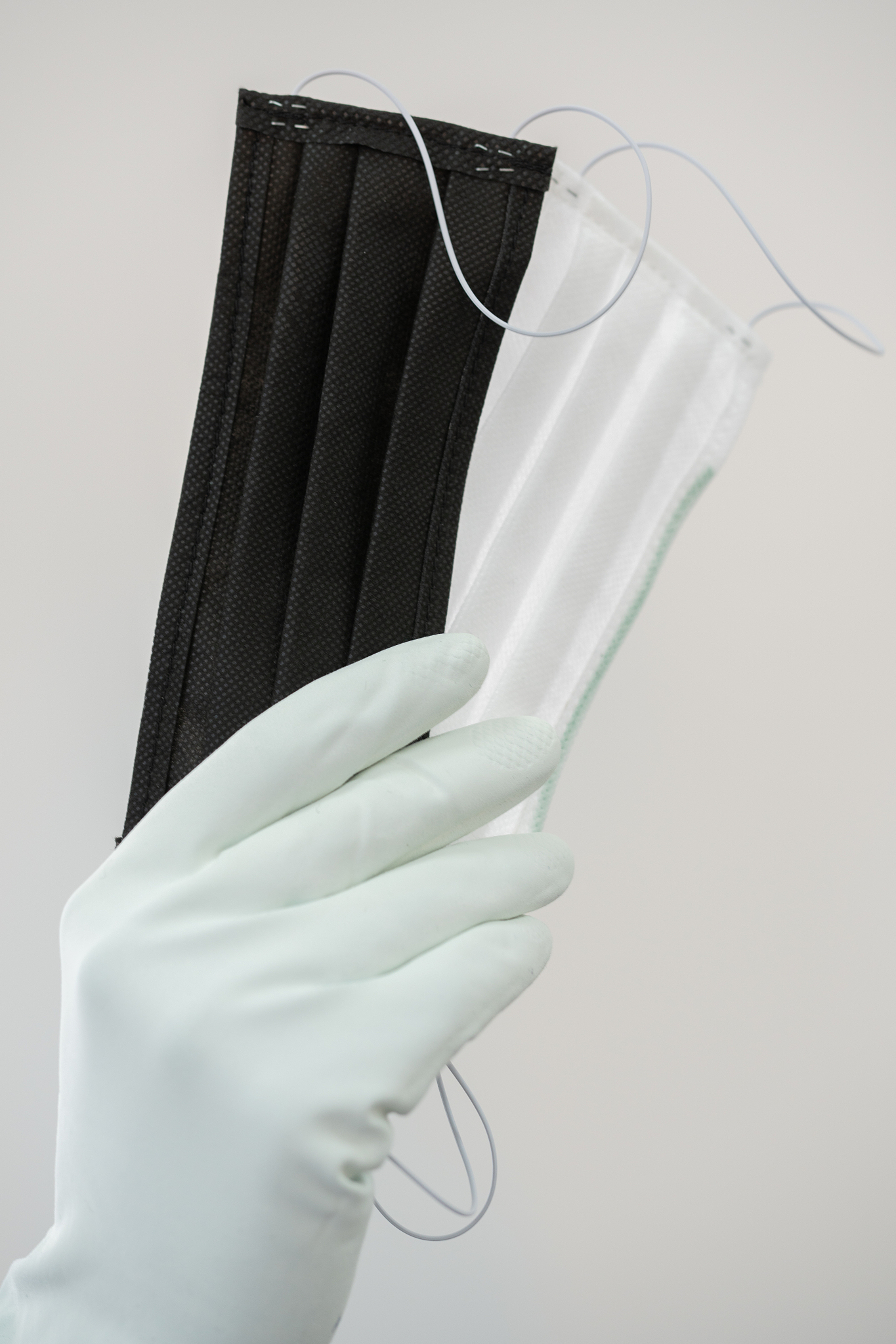 man holds rubber gloves black and white face masks