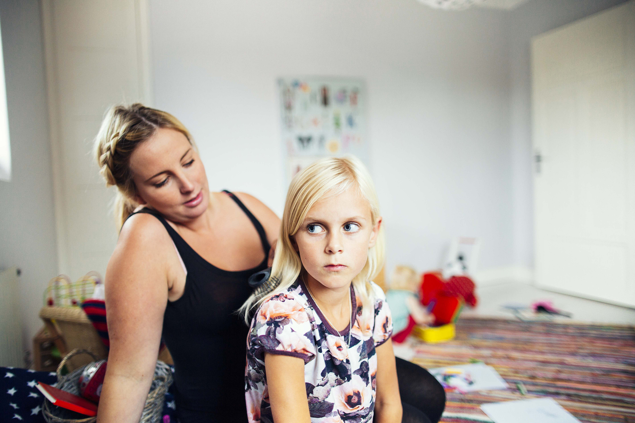 mother making daughters hair at home