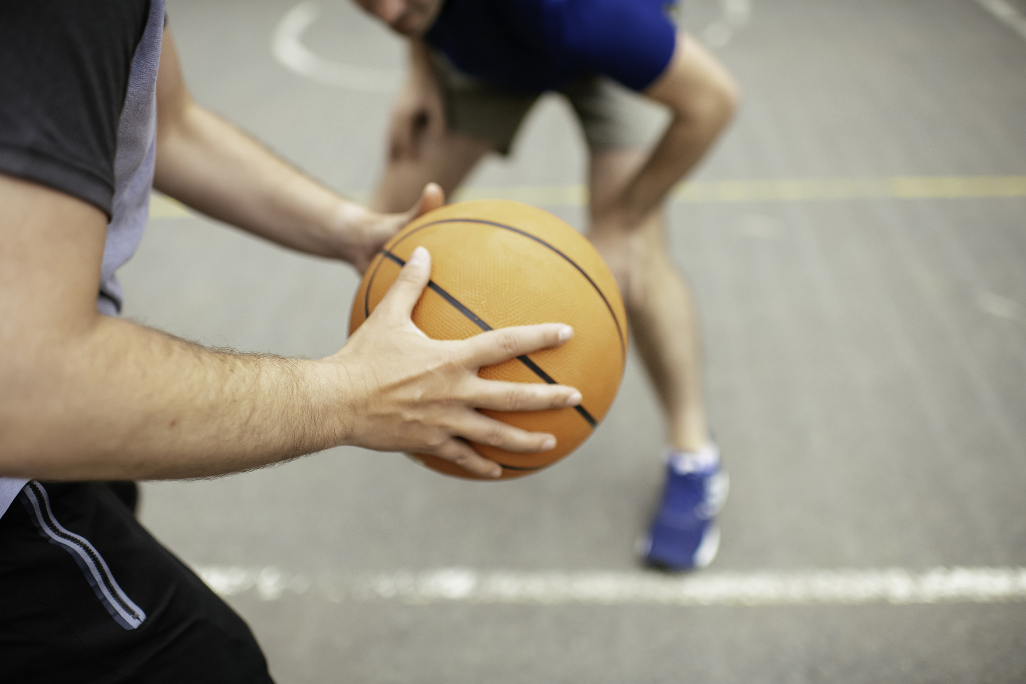close up of hands holding ball. friends playing basketball in th