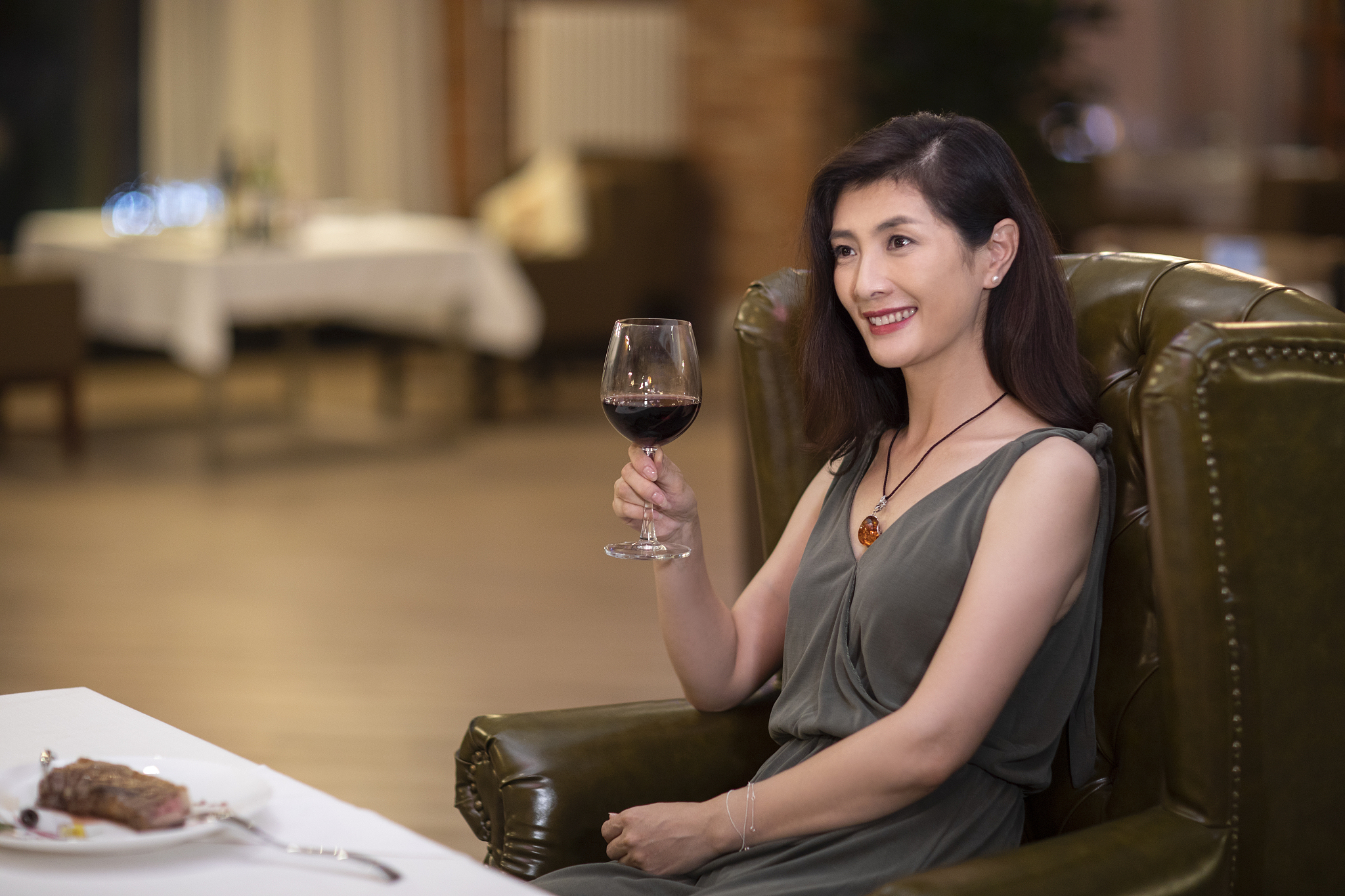 优雅女士在餐厅品尝红酒