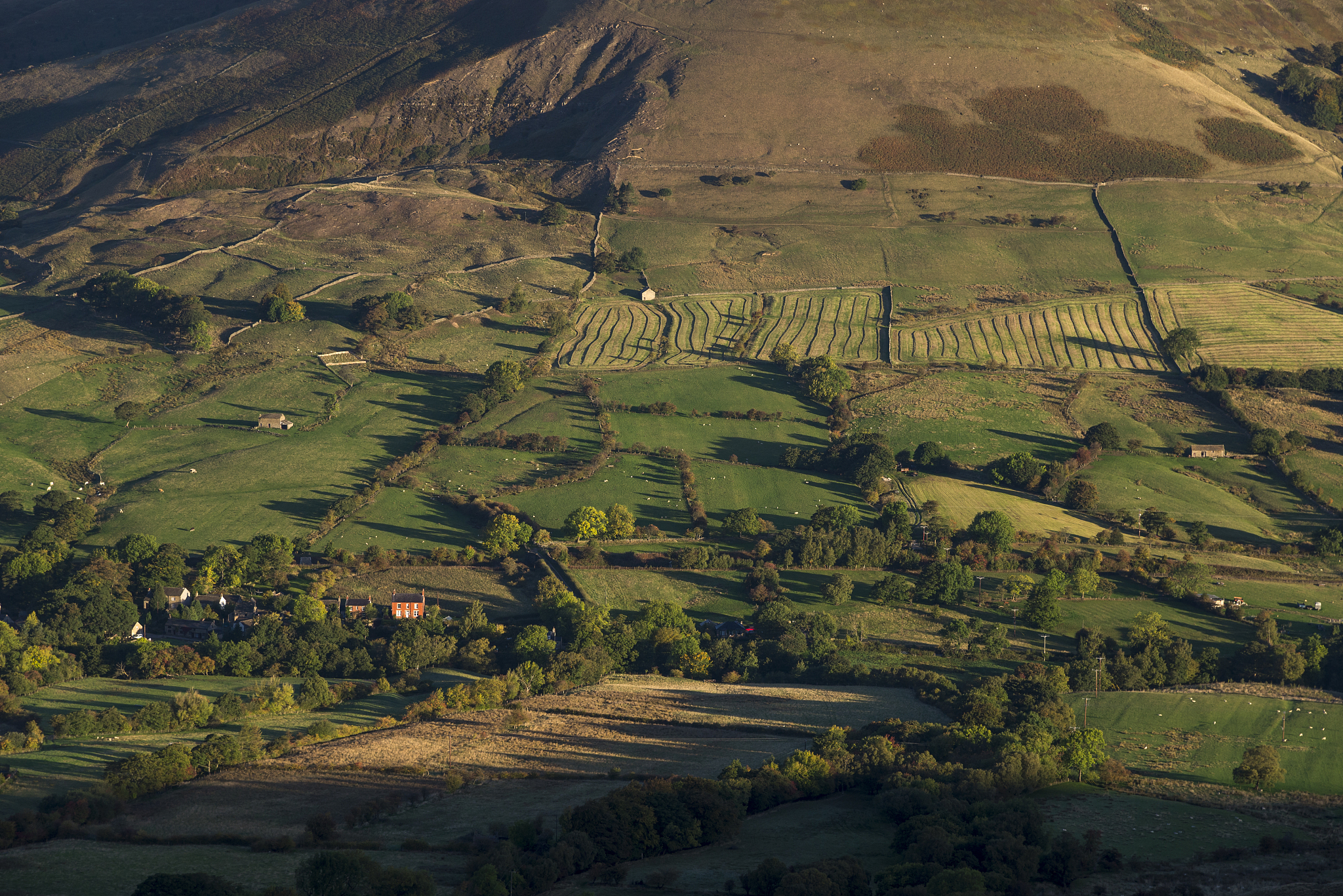 dawn sunlight on hillsides in the vale of edale, peak district, 